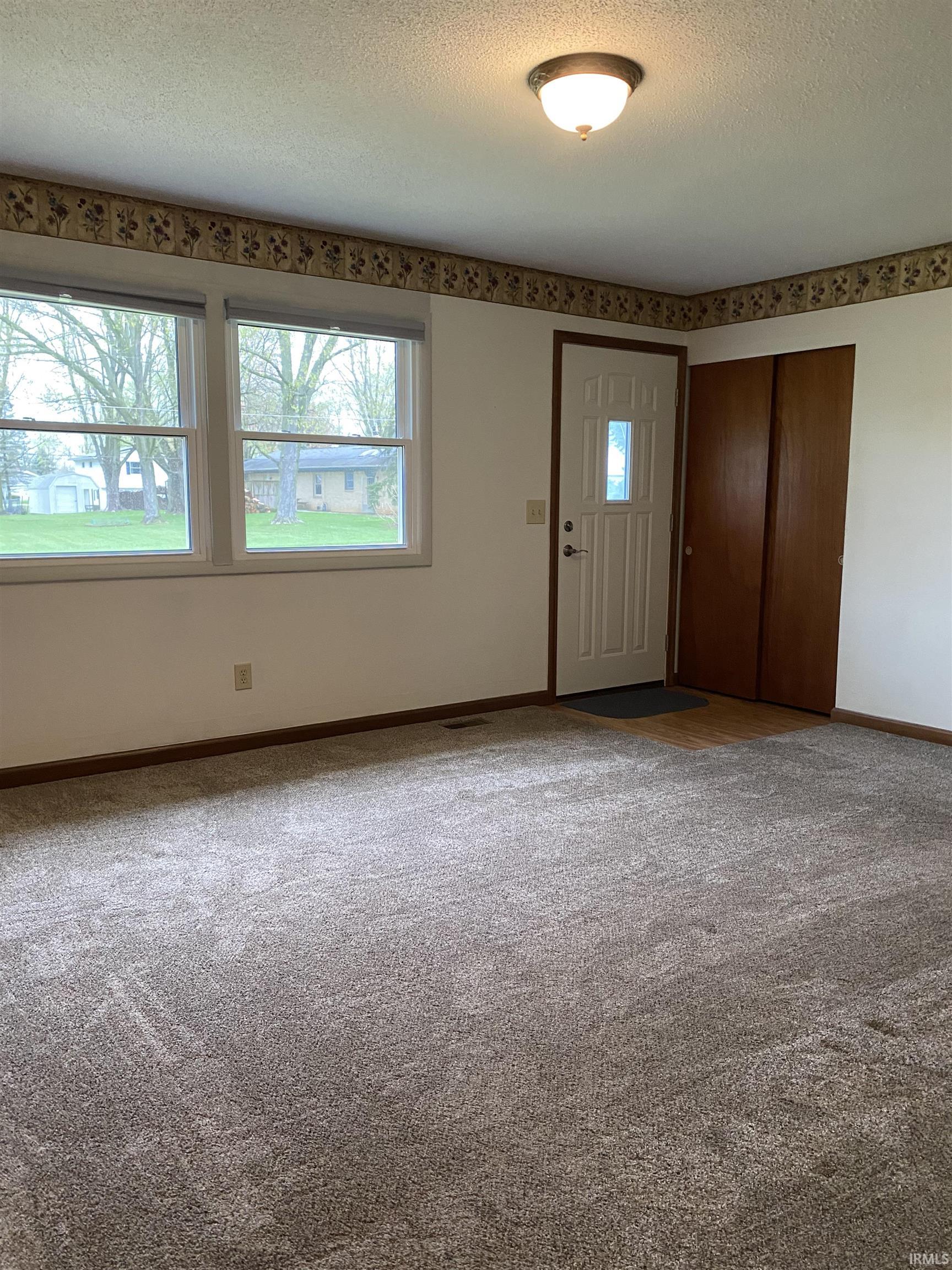 Carpeted living room with plenty of natural light.