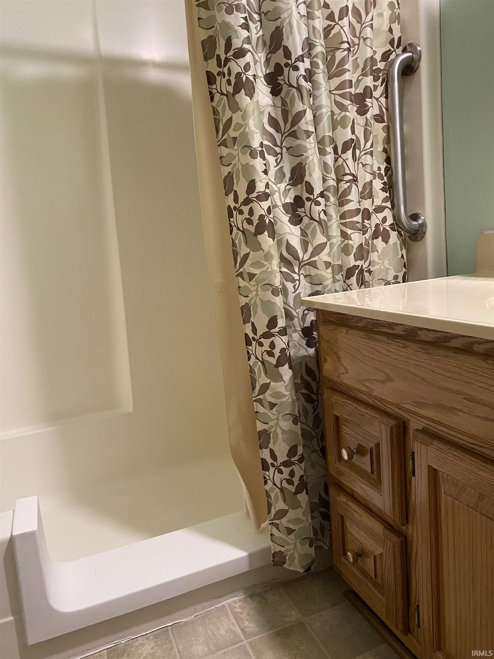 Bathroom featuring a walk-in shower and vanity.