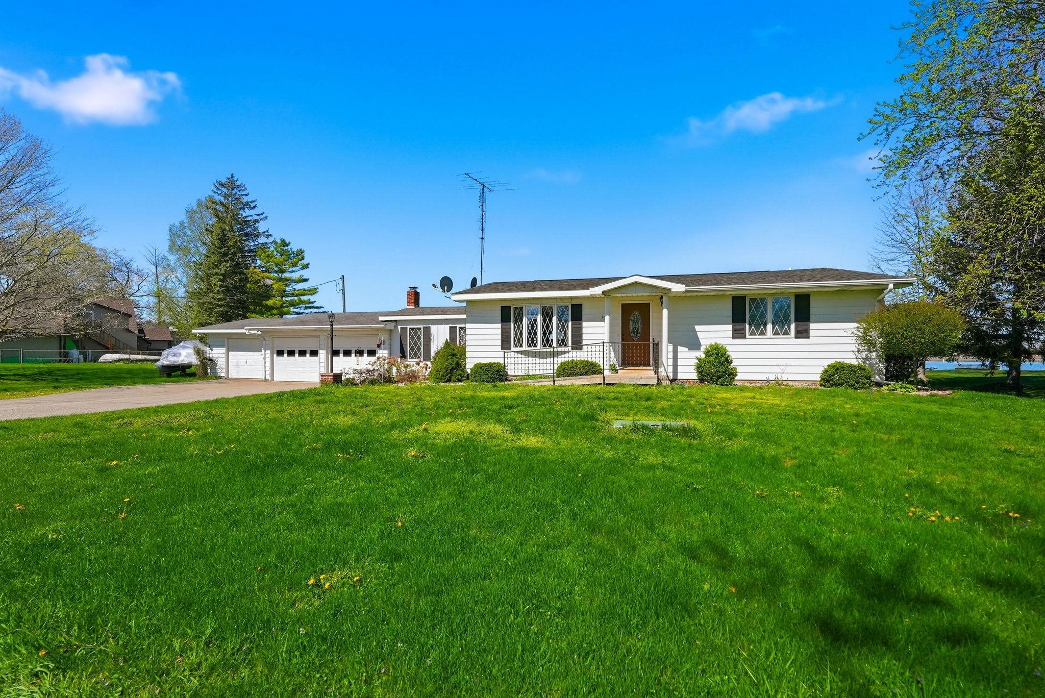 White ranch-style residence featuring a prominent front lawn