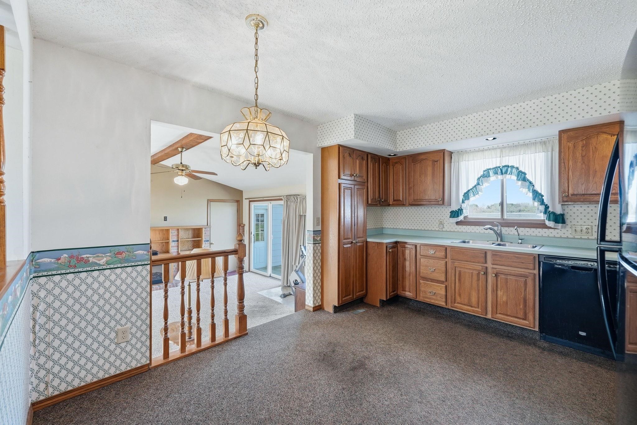 Kitchen featuring wood cabinetry, a double basin sink, and black appliances