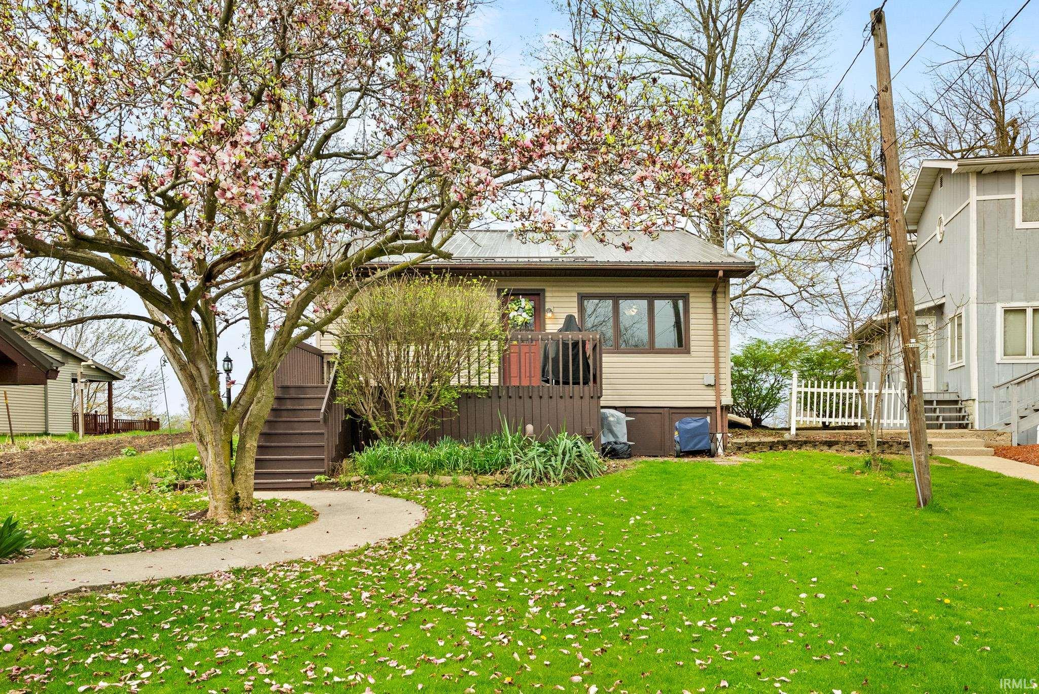 Bungalow-style home featuring a front lawn and a metal roof