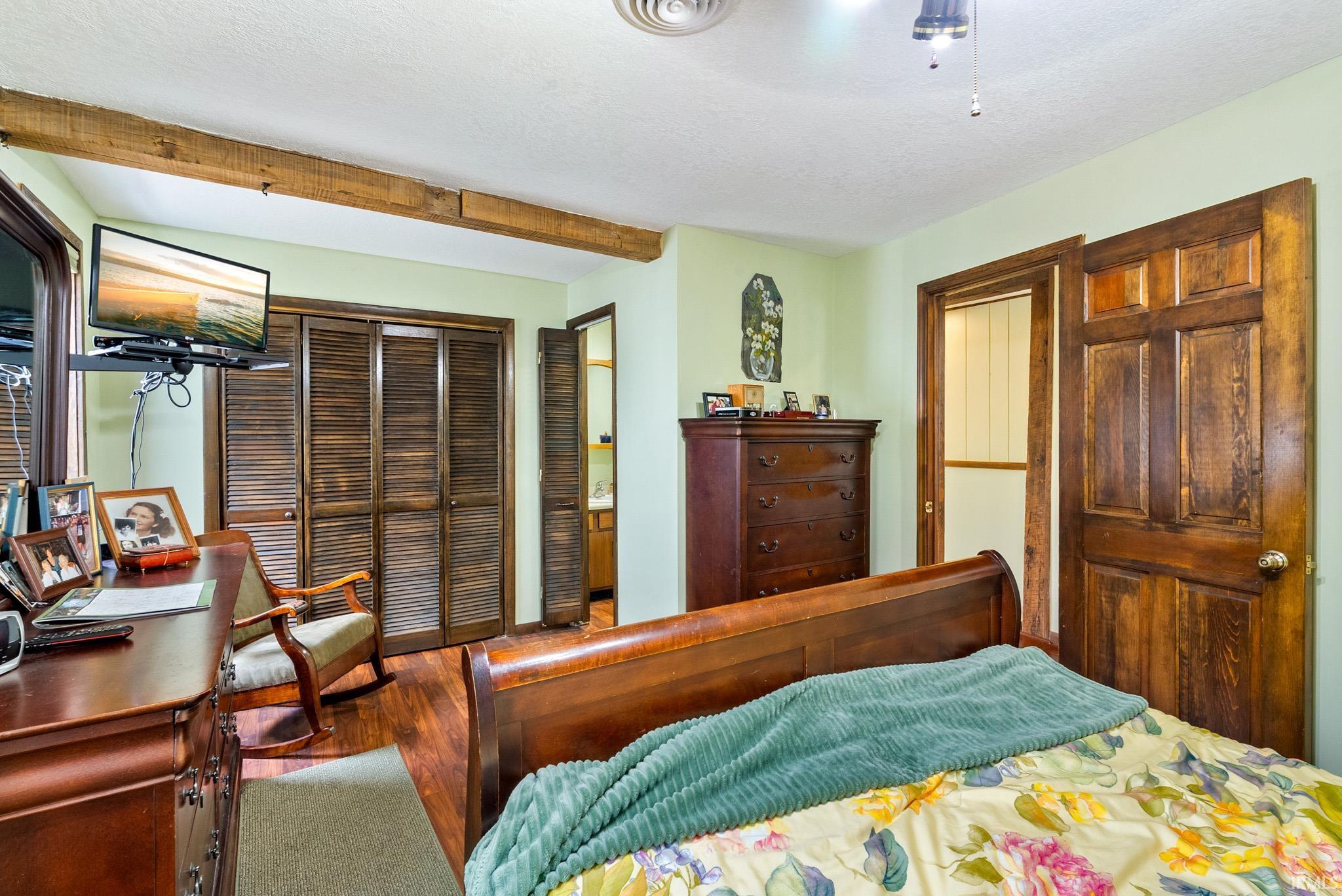 Bedroom featuring a desk, a textured ceiling, and wood finished floors