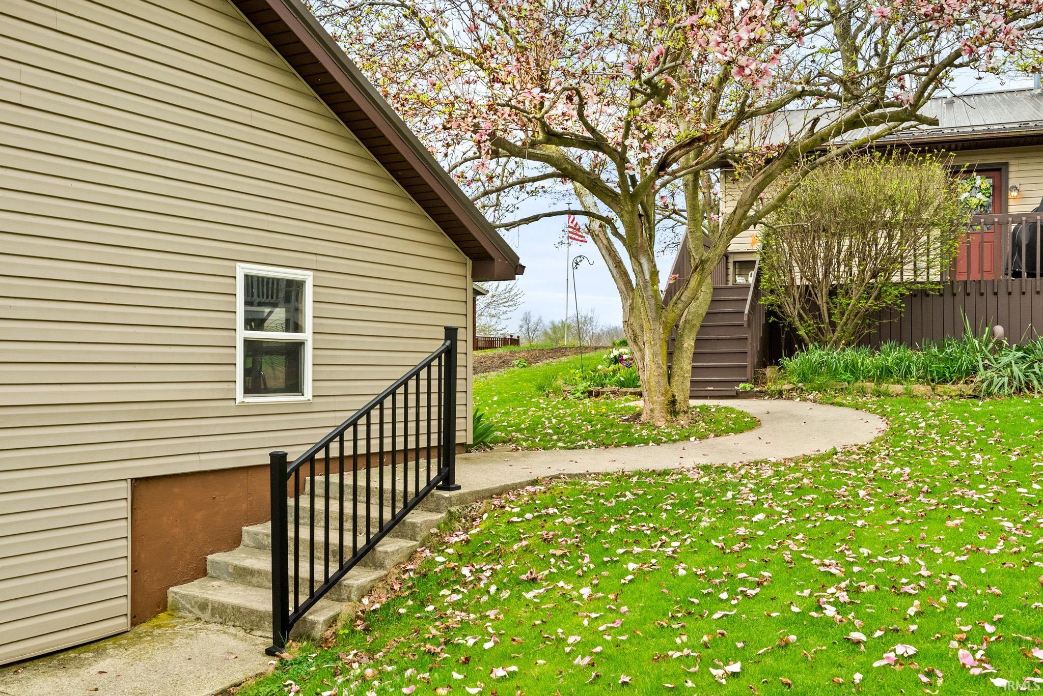 View of grassy yard featuring stairs