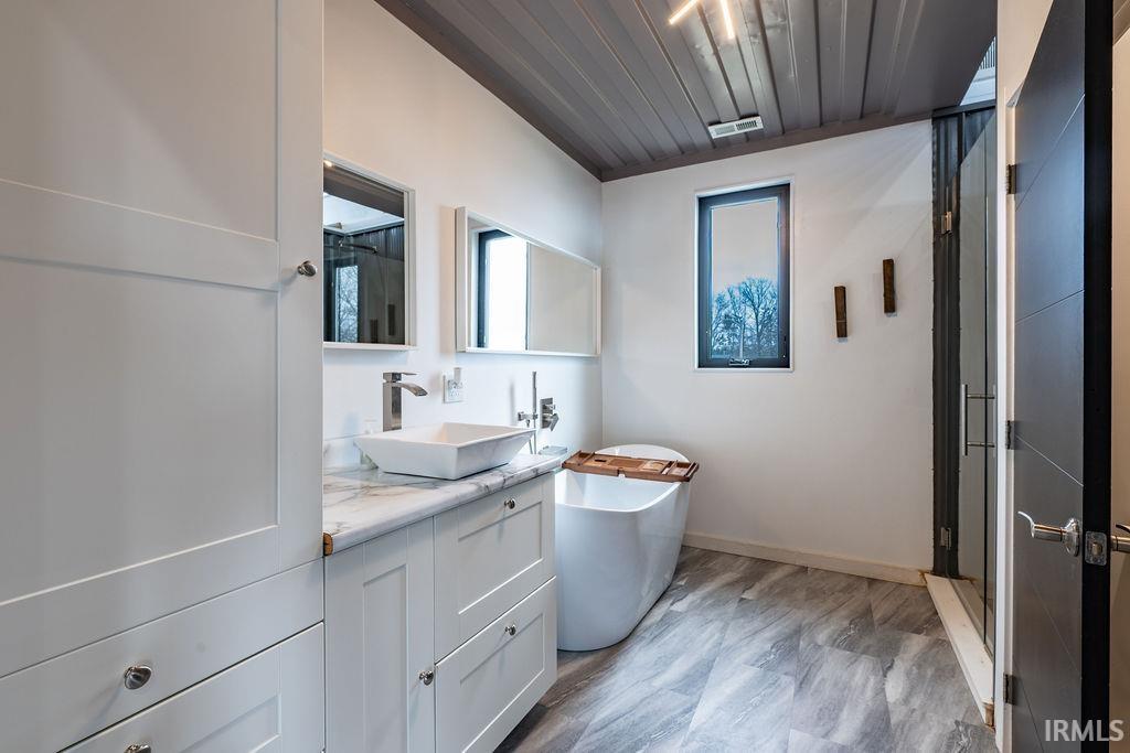 Bathroom with vanity, light wood finished floors, a stall shower, and a soaking tub