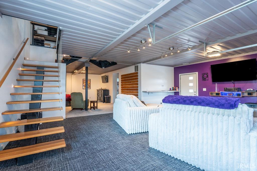 Living room with stairs and dark carpet