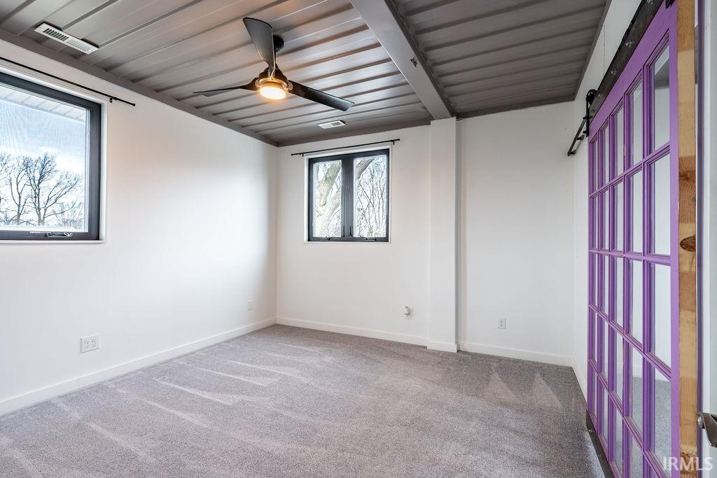 Carpeted spare room with baseboards