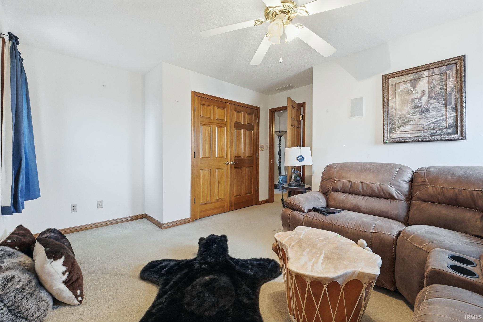 Living room with light colored carpet and a ceiling fan