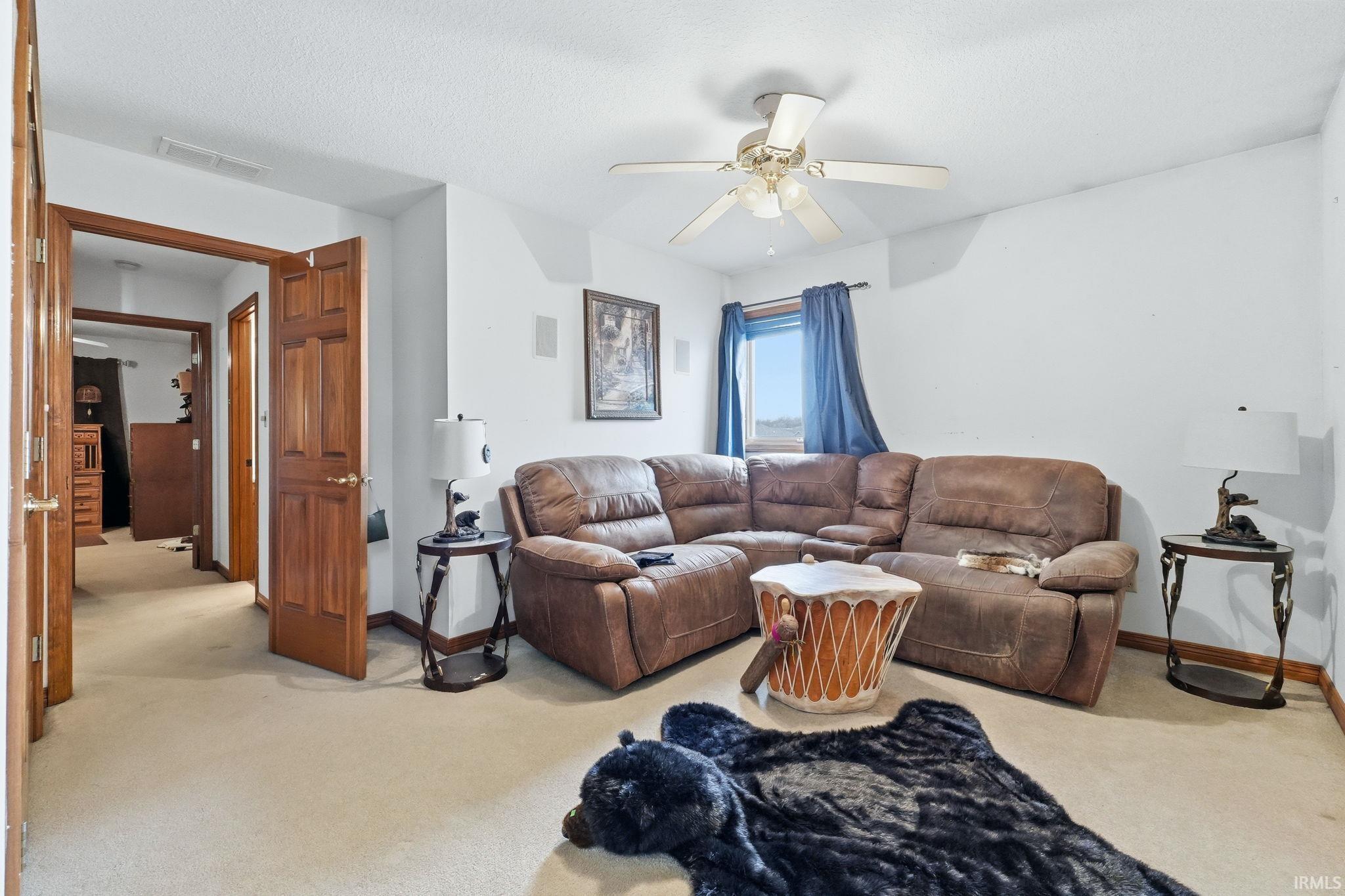 Living room with light colored carpet and ceiling fan