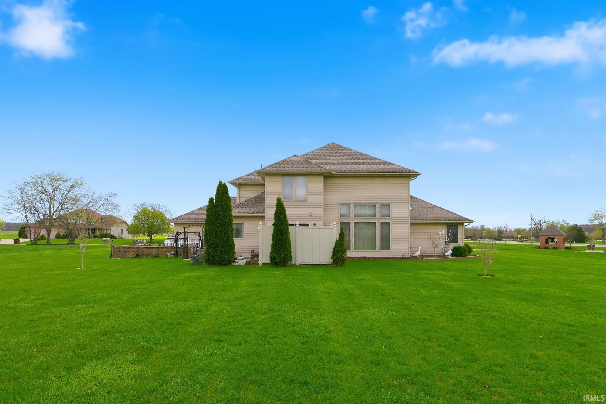 Rear view of property with a shingled roof and a yard
