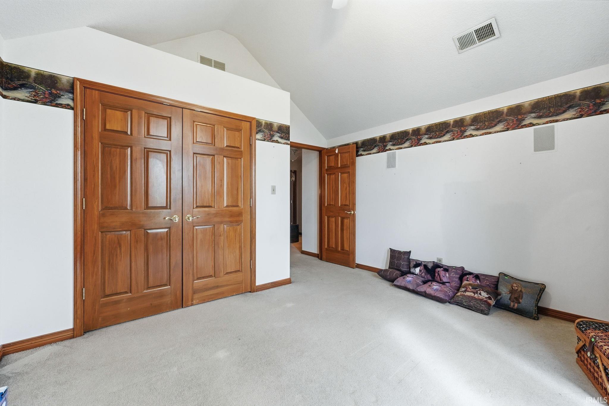 Unfurnished bedroom featuring light colored carpet and a closet