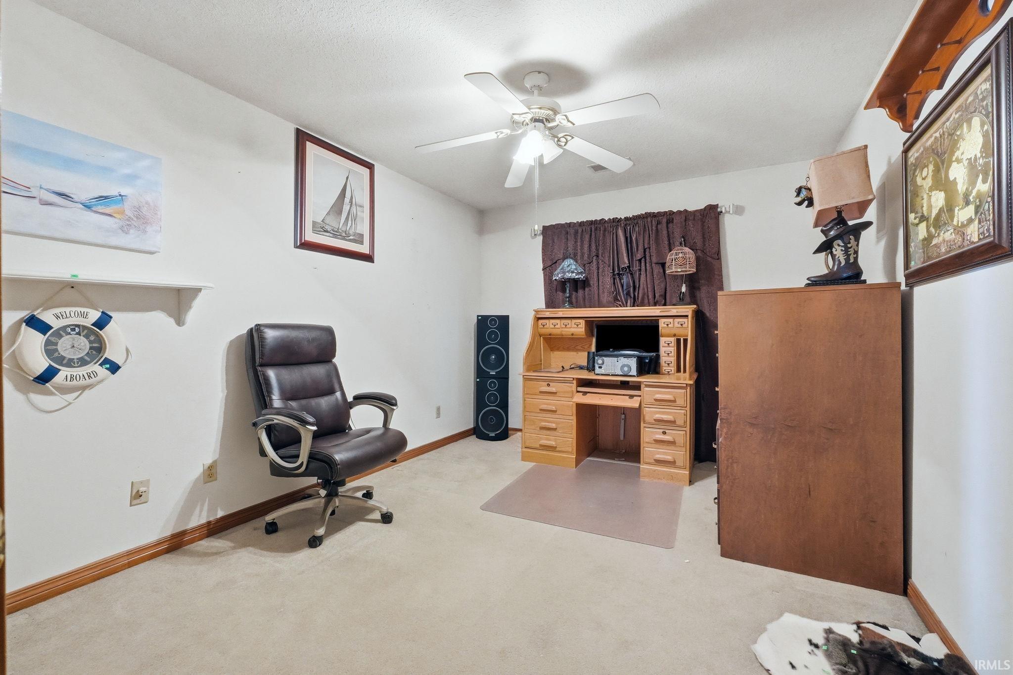 Home office featuring ceiling fan and light colored carpet
