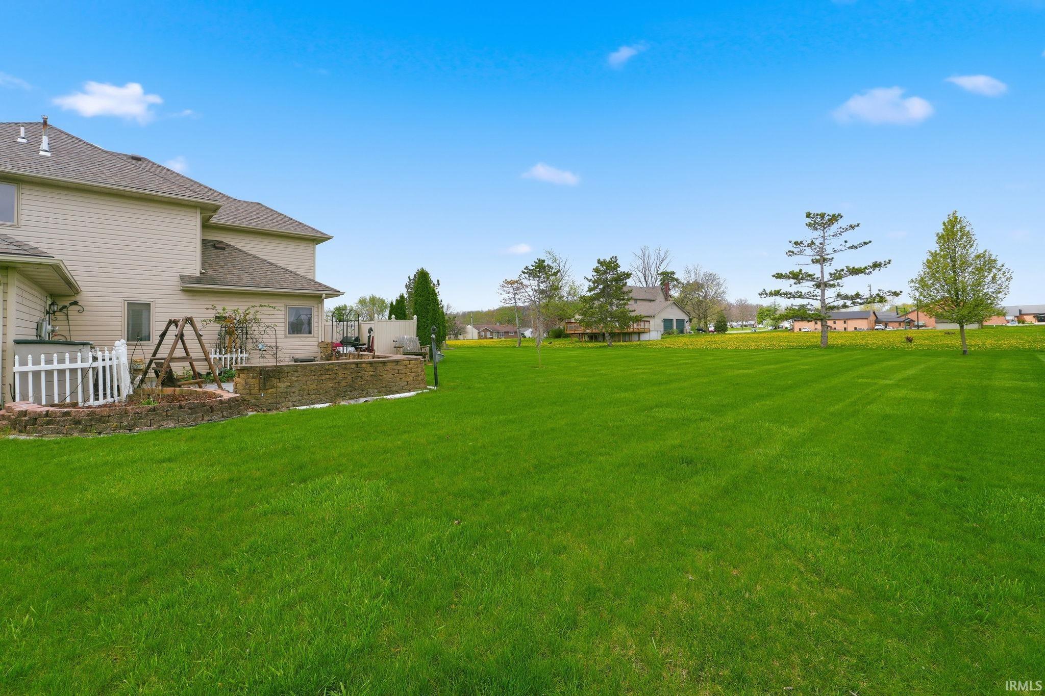 View of green lawn with a residential view and a patio