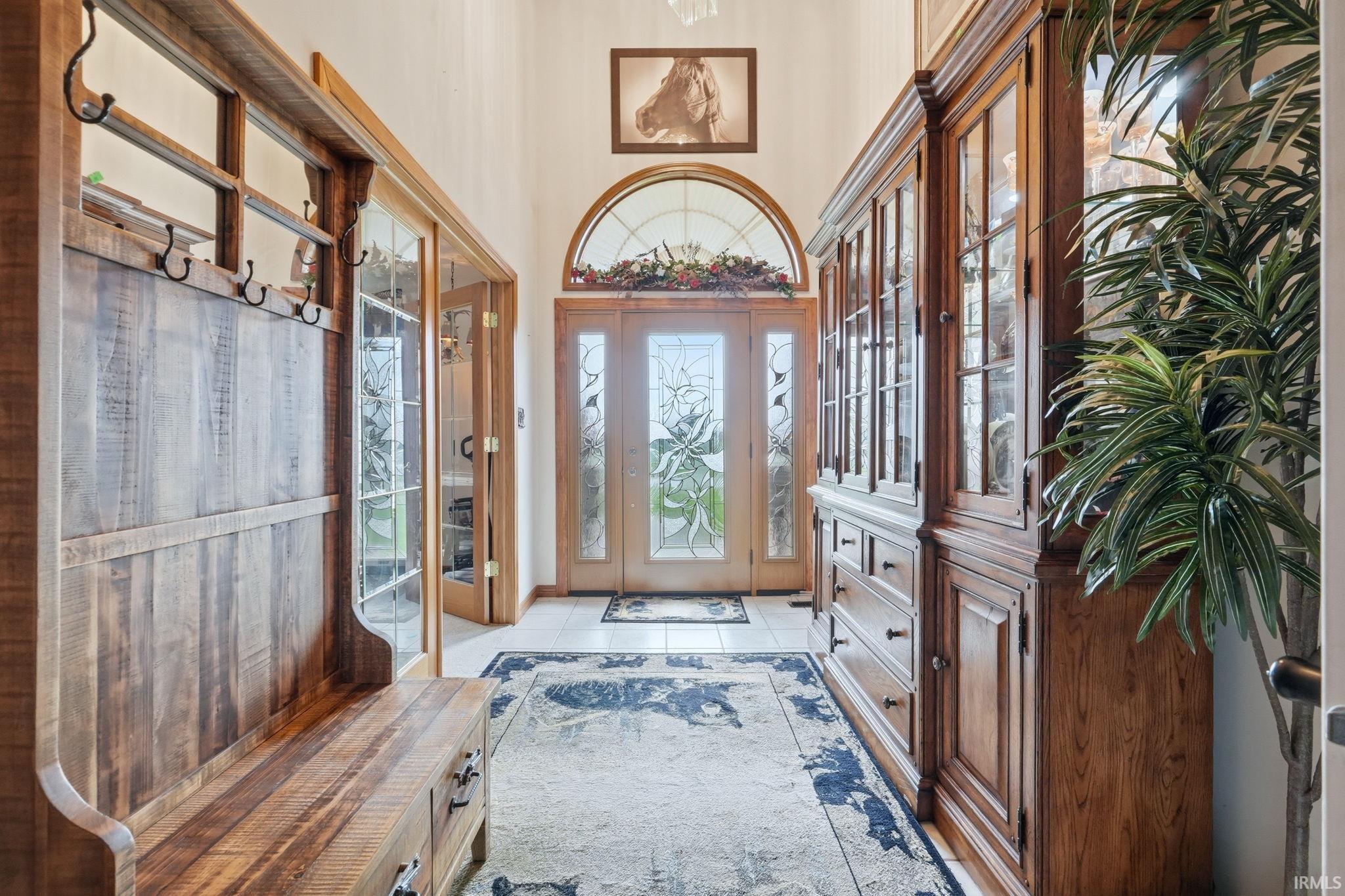 Foyer entrance with light tile patterned floors and a high ceiling