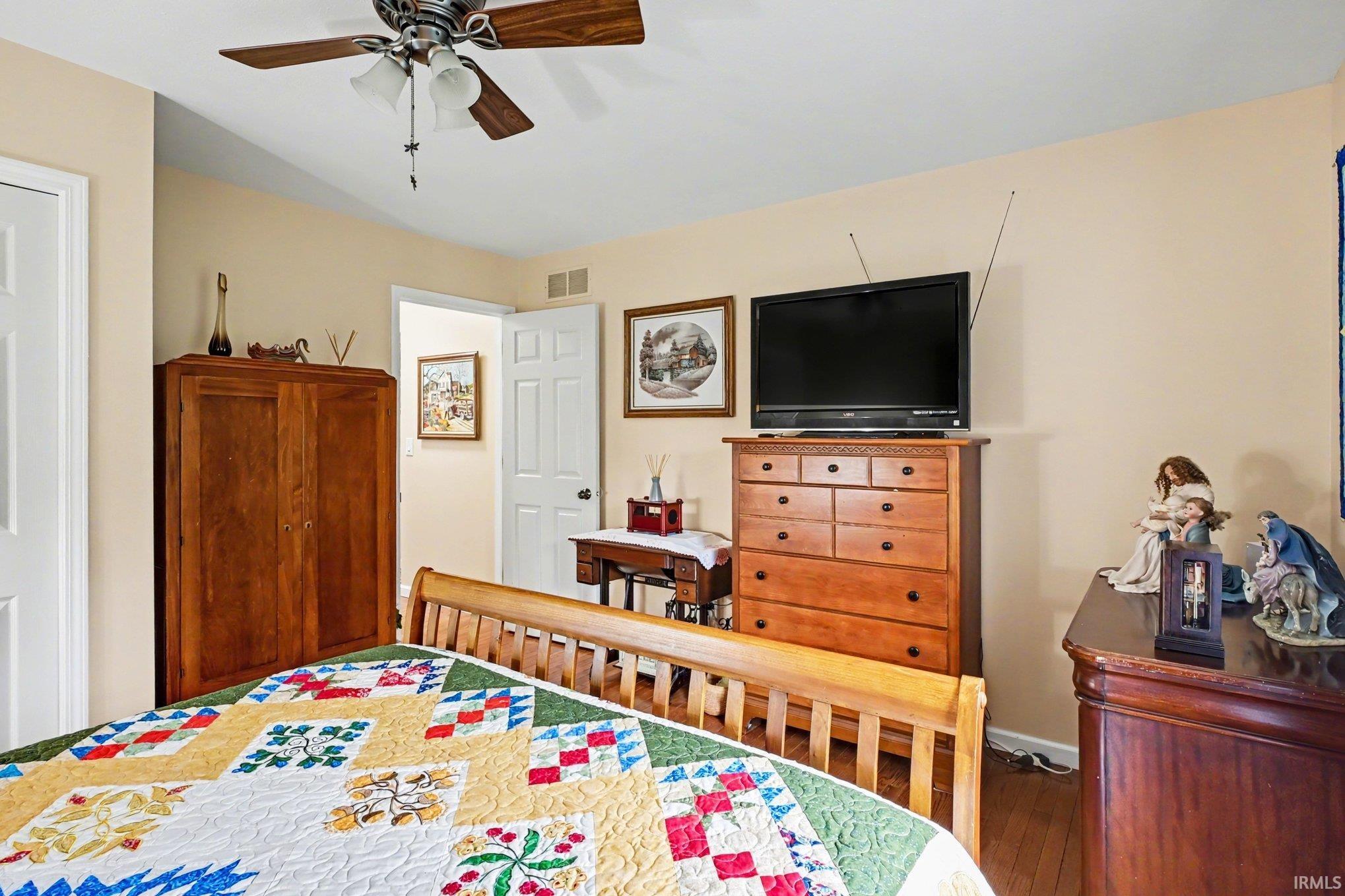 Bedroom with hardwood / wood-style flooring and a ceiling fan