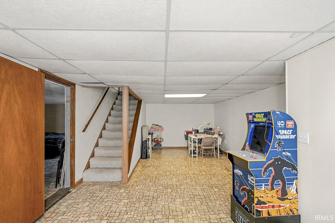 Game room featuring a paneled ceiling and light flooring