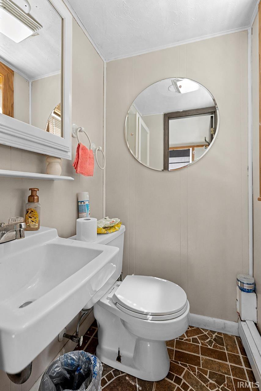 Bathroom featuring a decorative wall and ornamental molding
