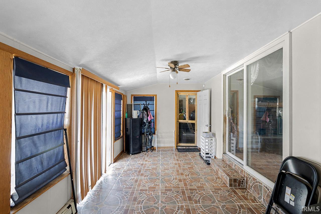 Sunroom / solarium featuring vaulted ceiling and a baseboard radiator