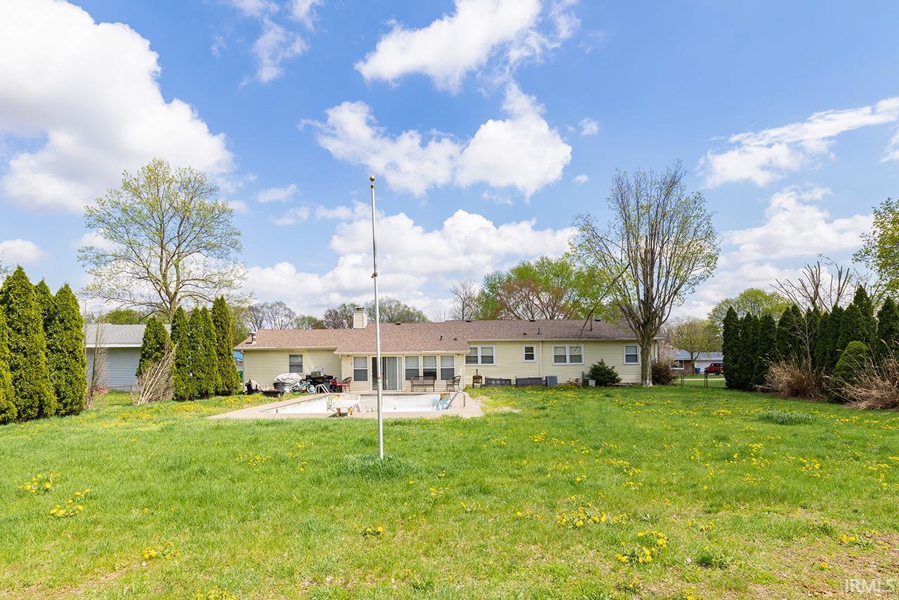 Rear view of house with a yard and a patio