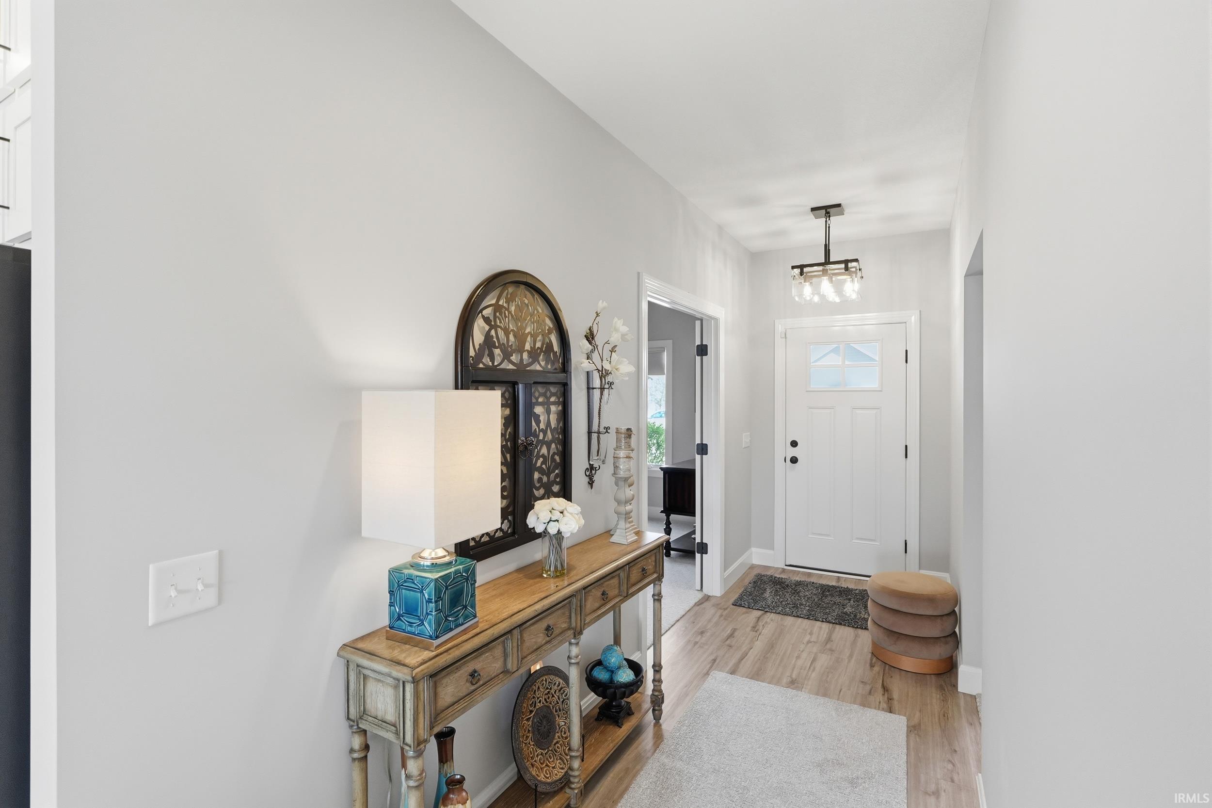 Foyer with light wood-type flooring and baseboards