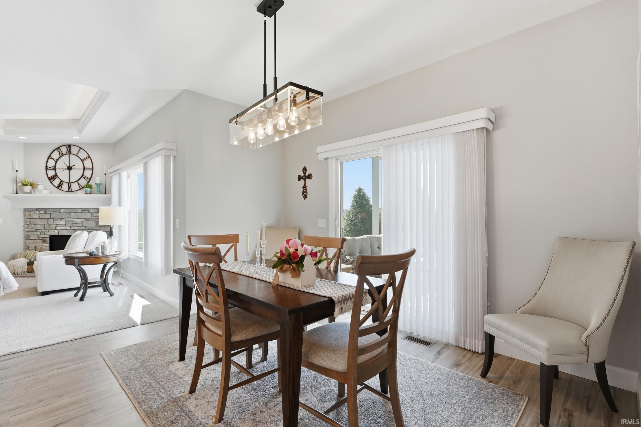 Dining room with light wood finished floors and a stone fireplace