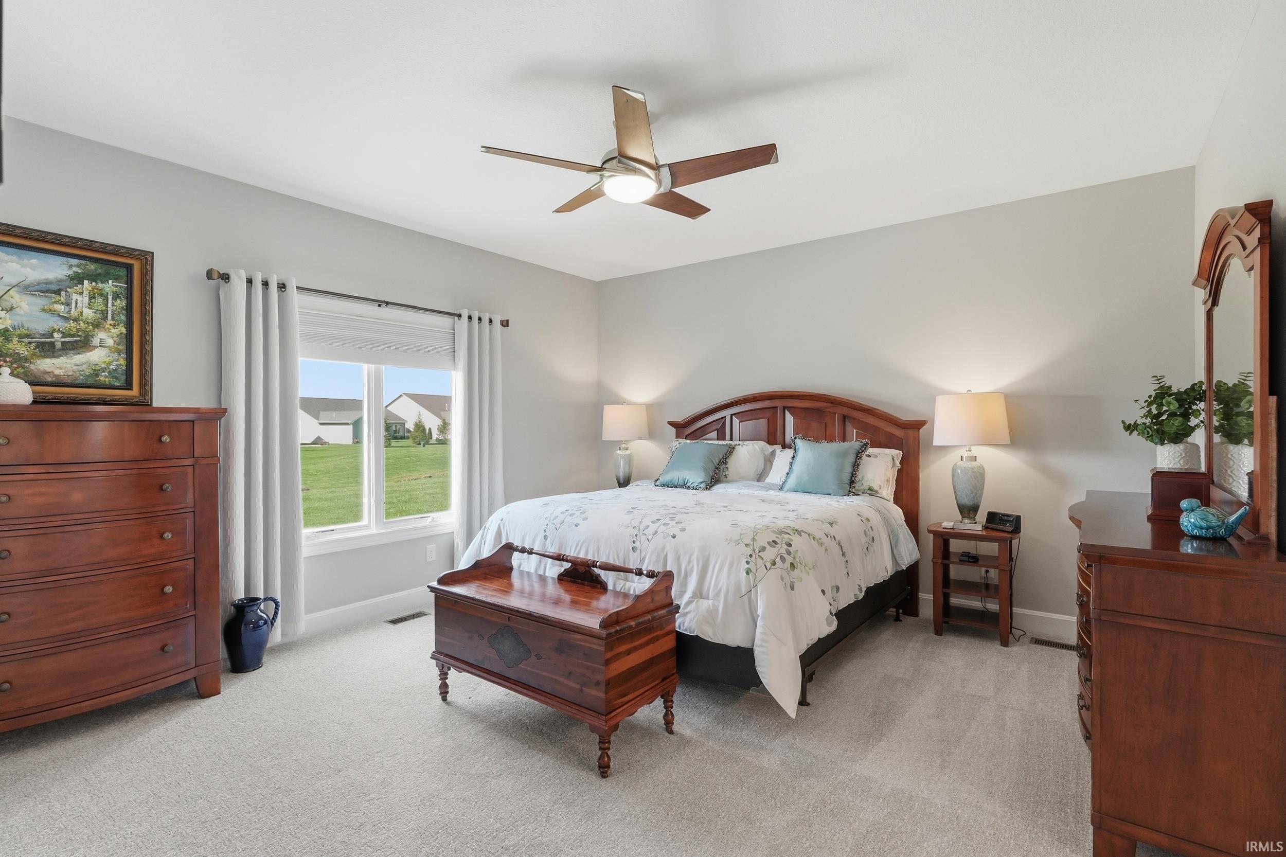 Bedroom with light colored carpet and ceiling fan