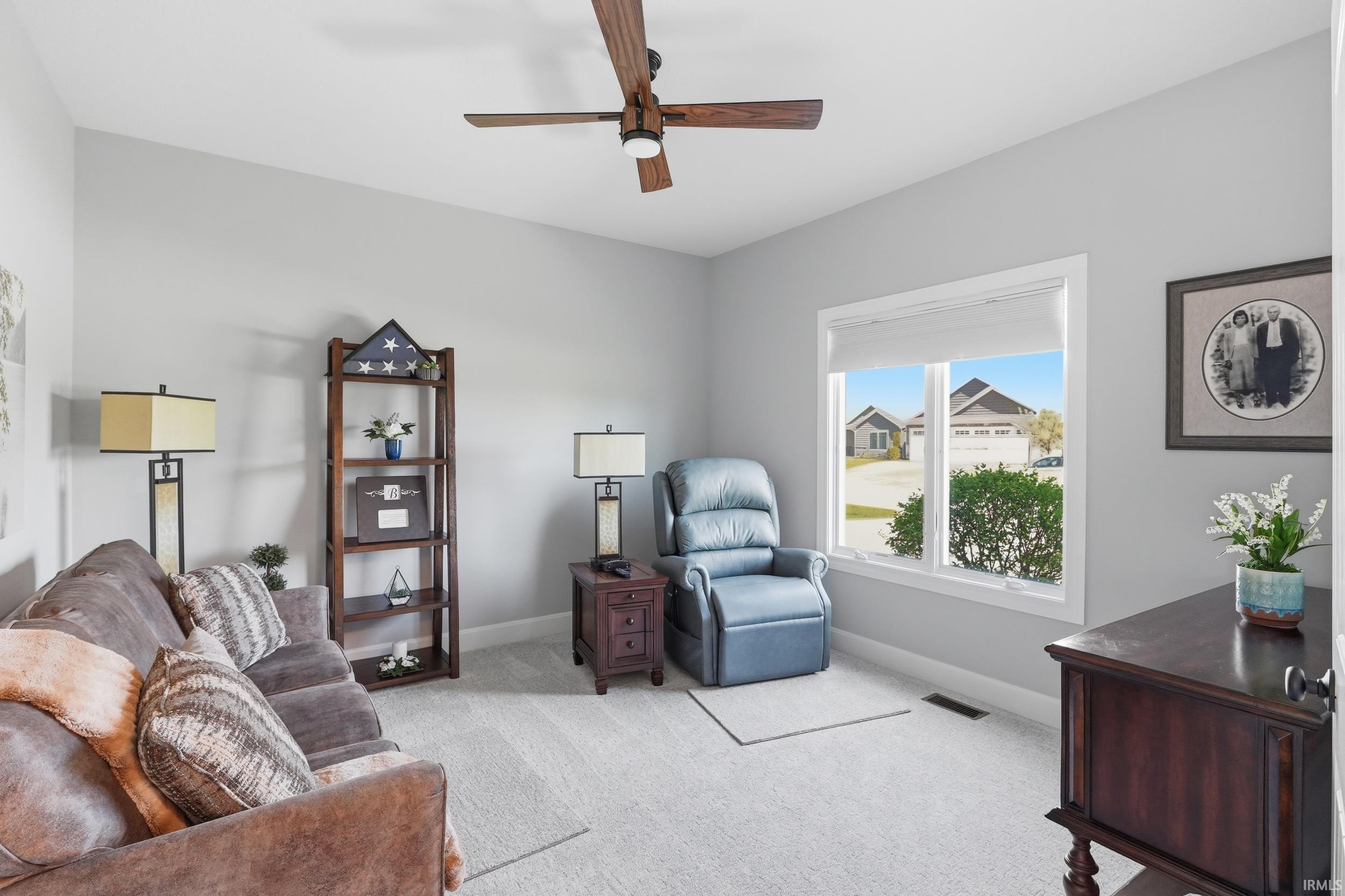 Living room with carpet floors and a ceiling fan