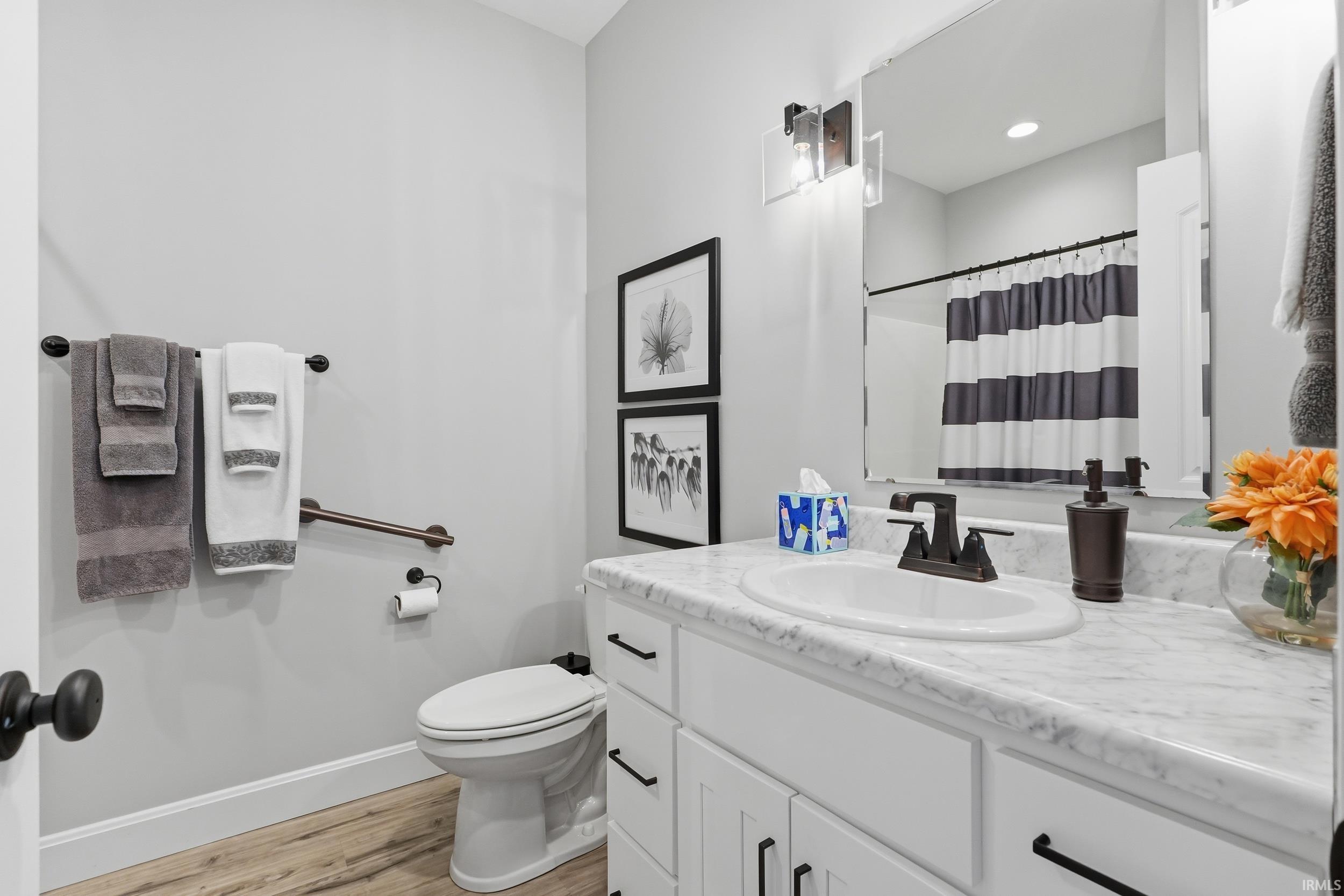 Bathroom featuring vanity, a shower with curtain, and light wood-type flooring