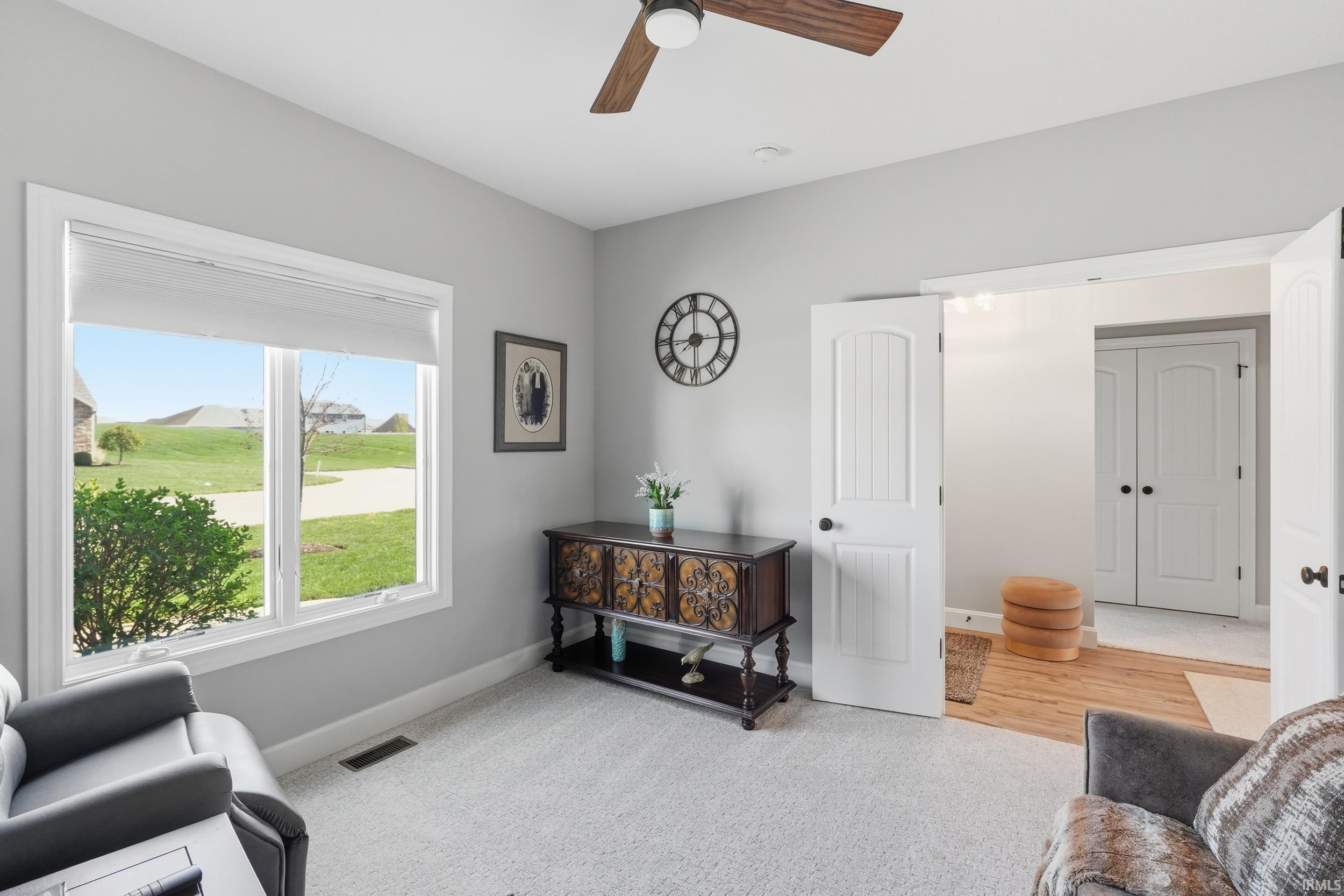 Sitting room featuring ceiling fan and light colored carpet