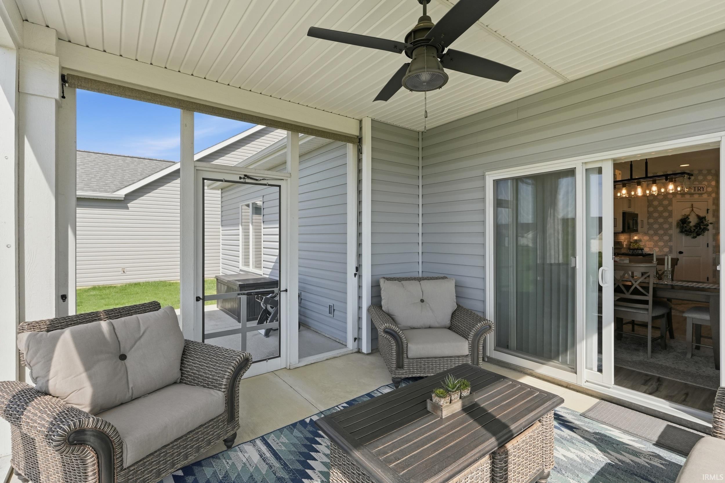 Sunroom / solarium featuring a ceiling fan, an outdoor hangout area, and a patio area