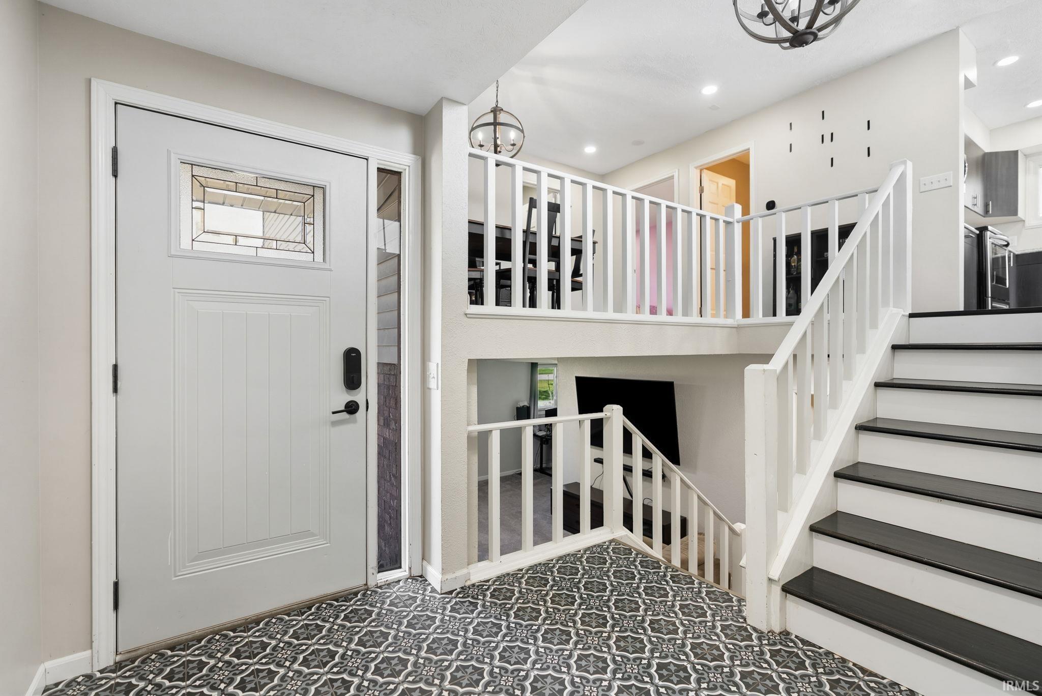 Foyer with suspended lighting and stairway