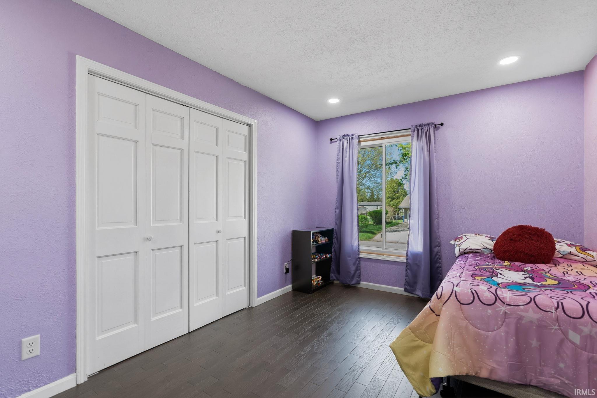 Bedroom with dark wood finished floors, a closet, recessed lighting, and a textured ceiling
