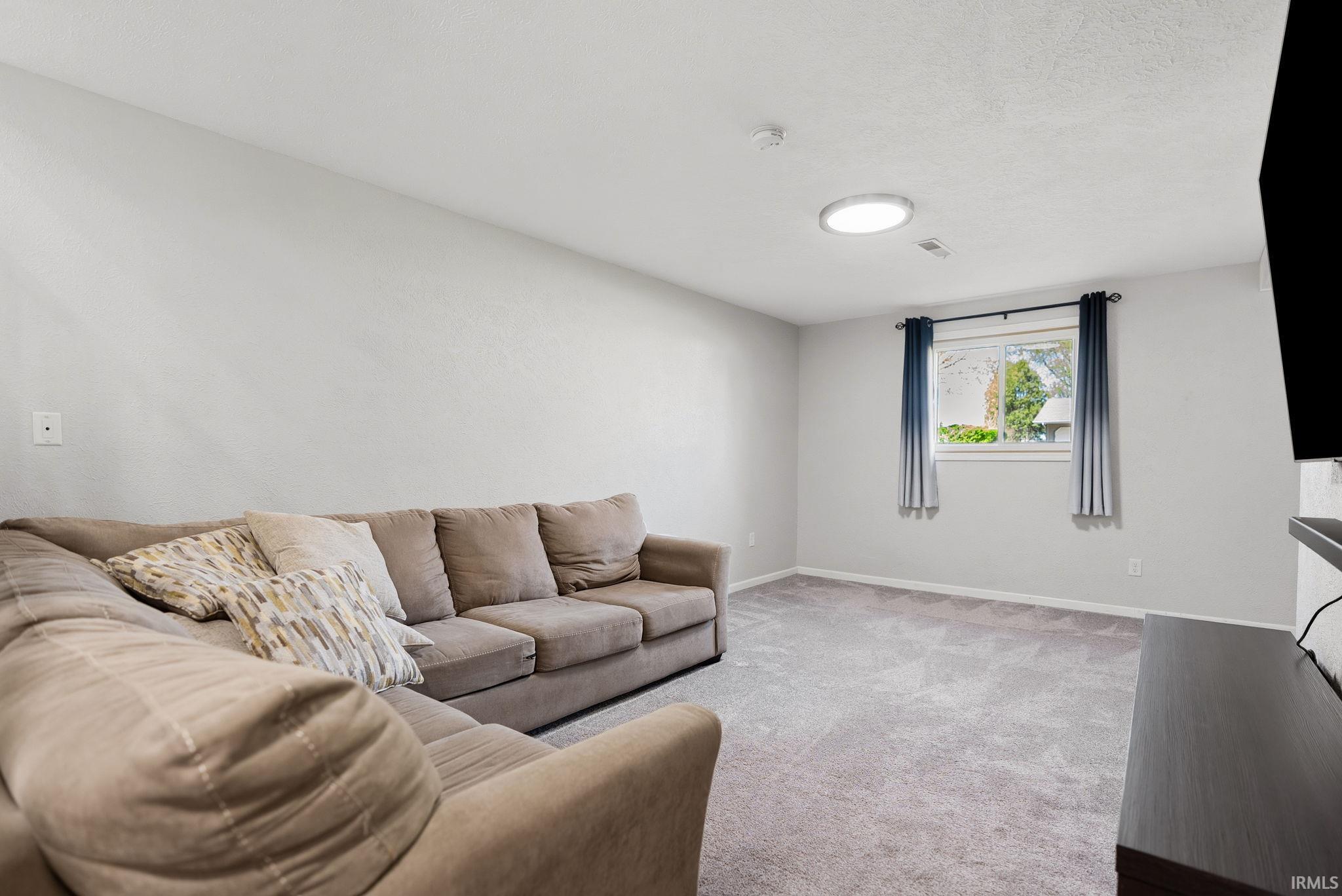 Living room featuring light colored carpet and baseboards