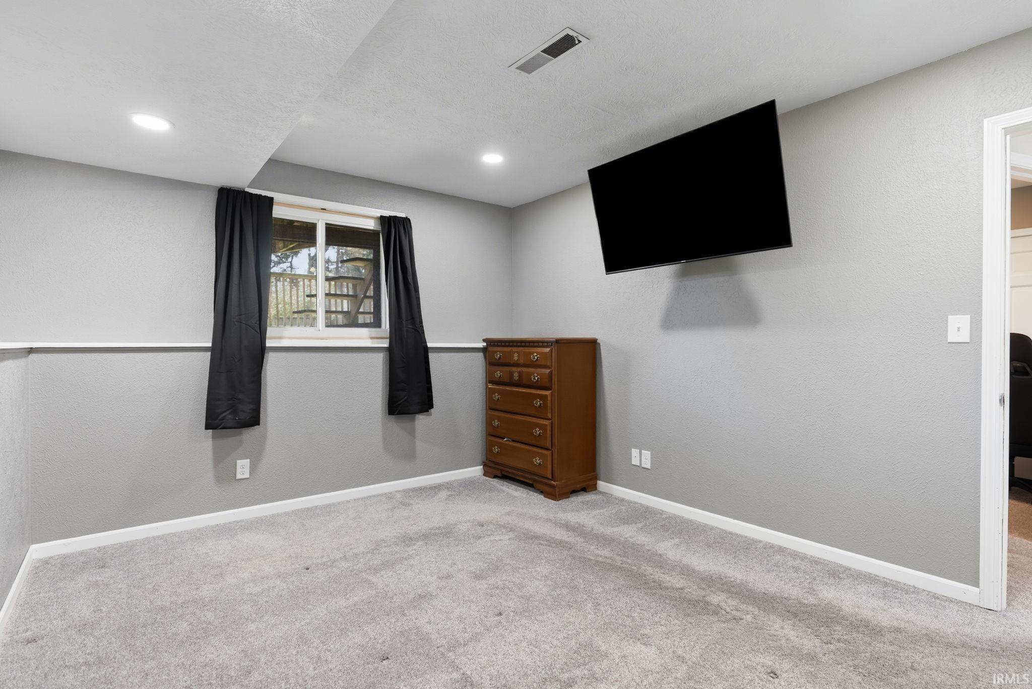 Unfurnished bedroom featuring carpet and a textured wall