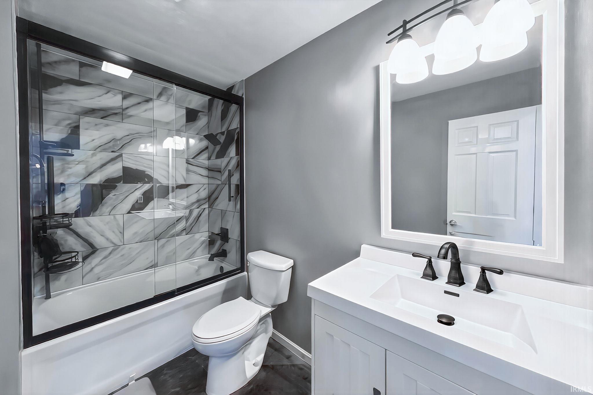 Bathroom with vanity and shower / bath combination with glass door