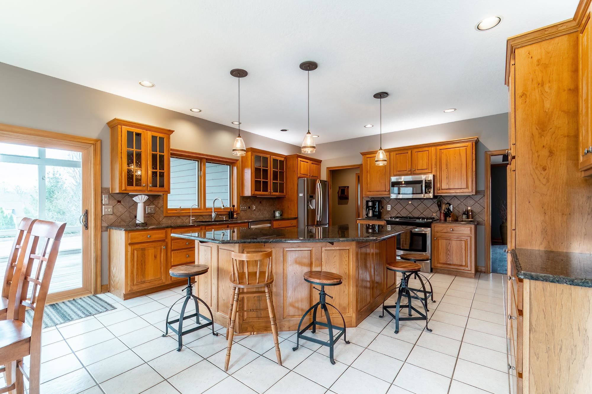 Kitchen featuring a breakfast bar area, stainless steel appliances, dark stone countertops, and wood finish cabinets