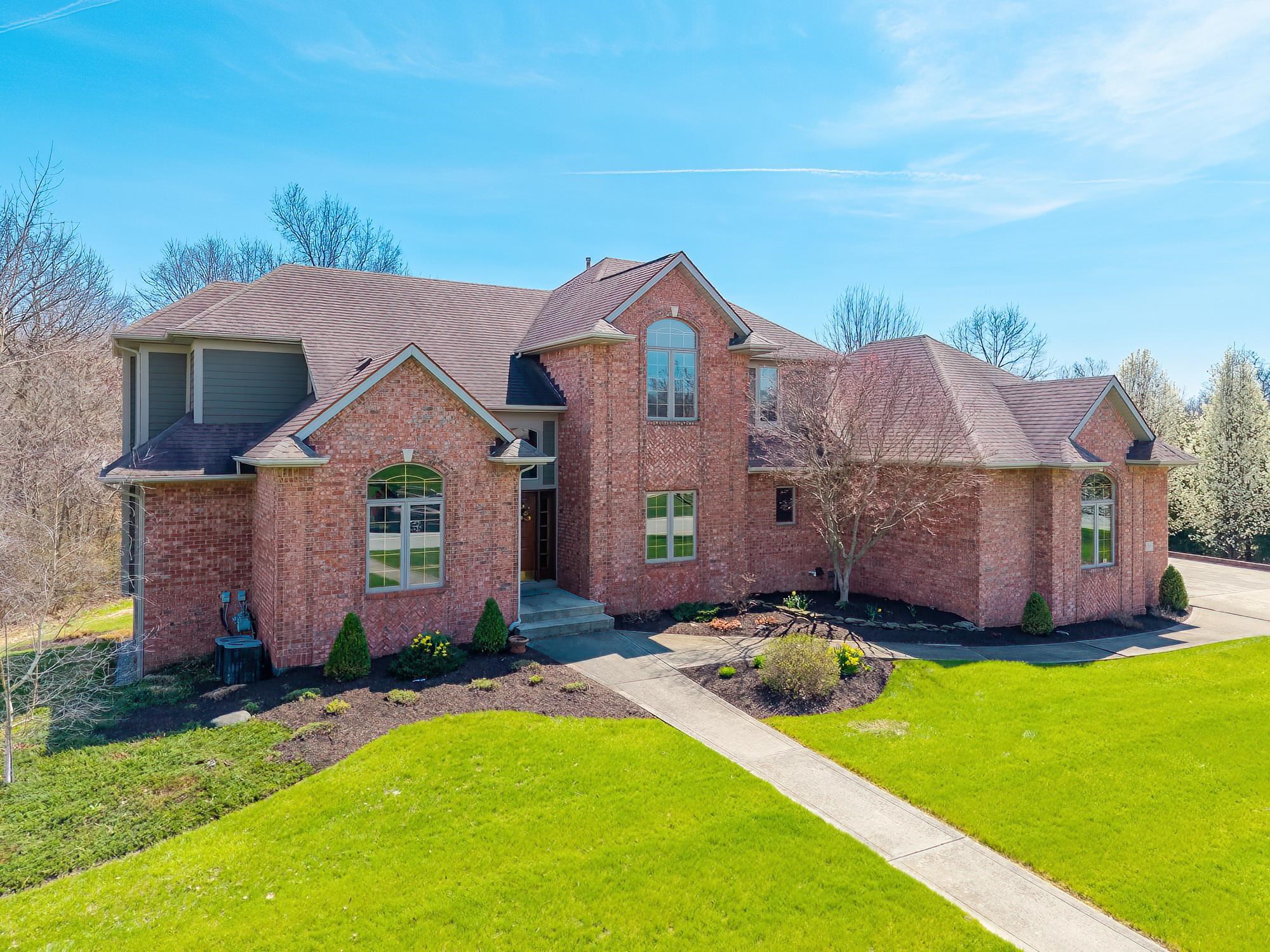 Traditional-style house featuring a front yard, brick siding, and a shingled roof