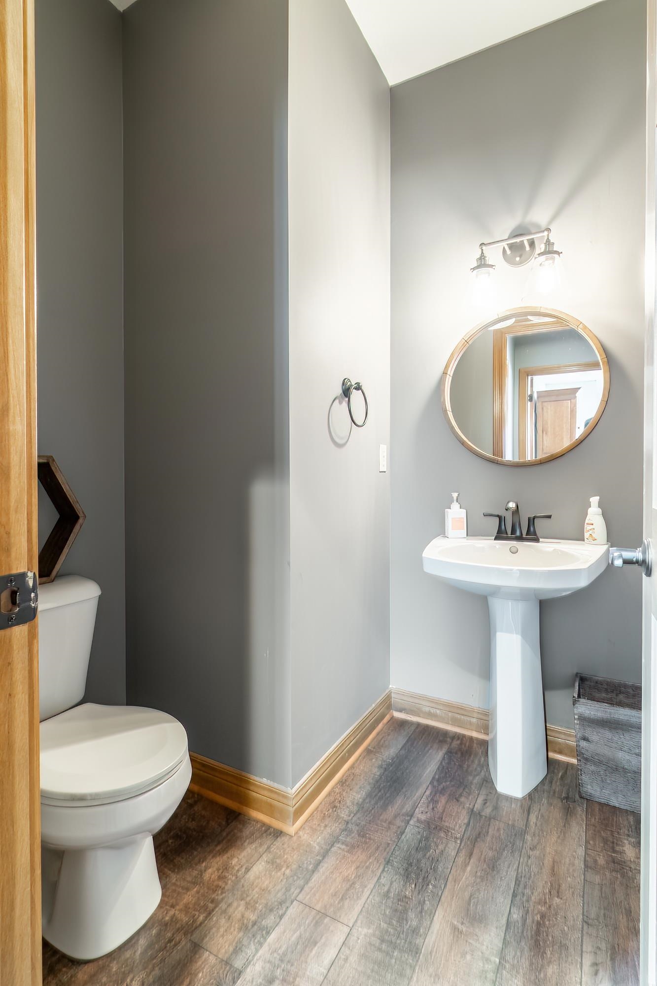 Bathroom featuring dark wood-style flooring and toilet