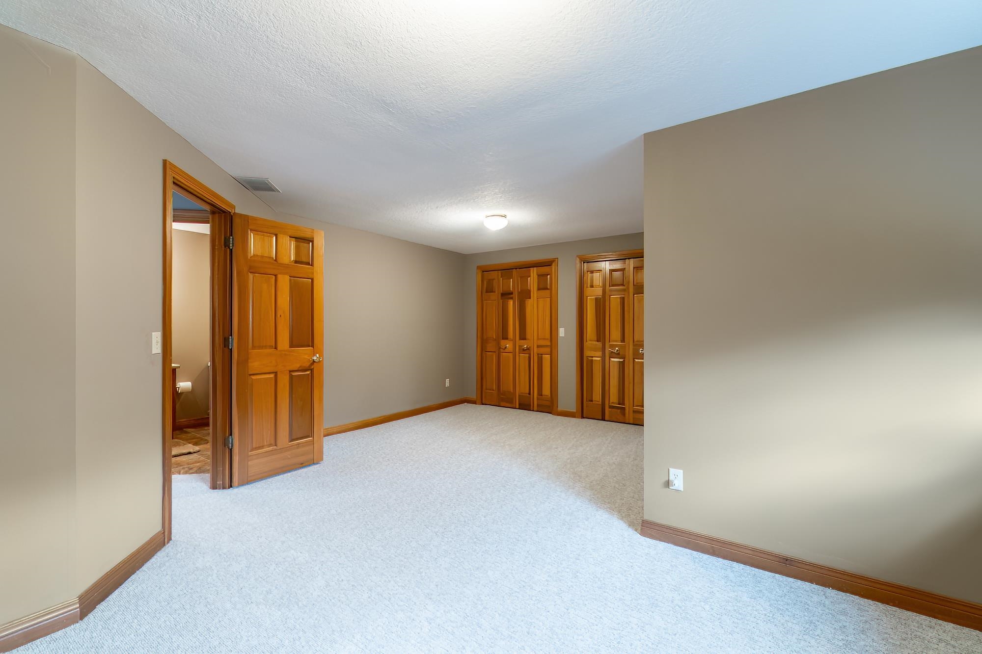 Empty room featuring light carpet and a textured ceiling