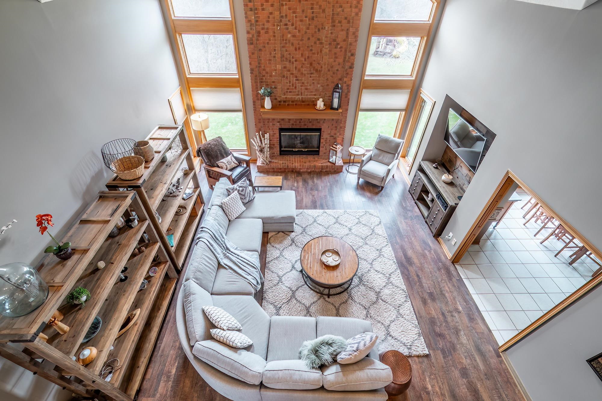 Living room with dark wood-style flooring, a fireplace, a high ceiling, and plenty of natural light