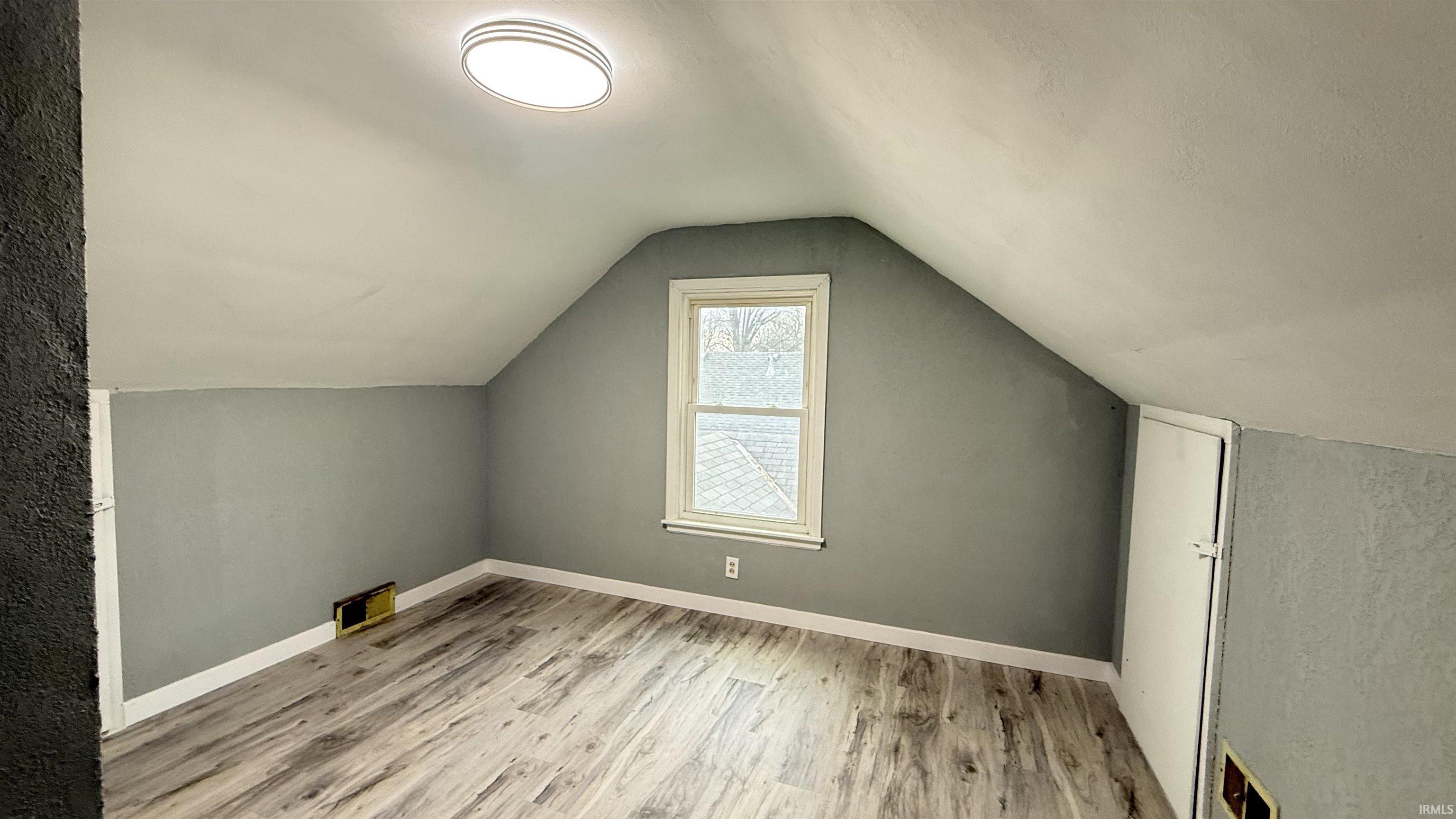 Additional living space featuring baseboards and light wood-style flooring