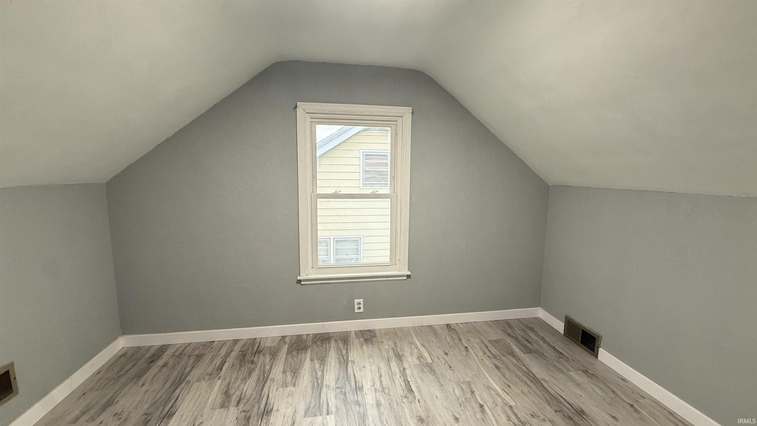 Bonus room featuring light wood finished floors and baseboards