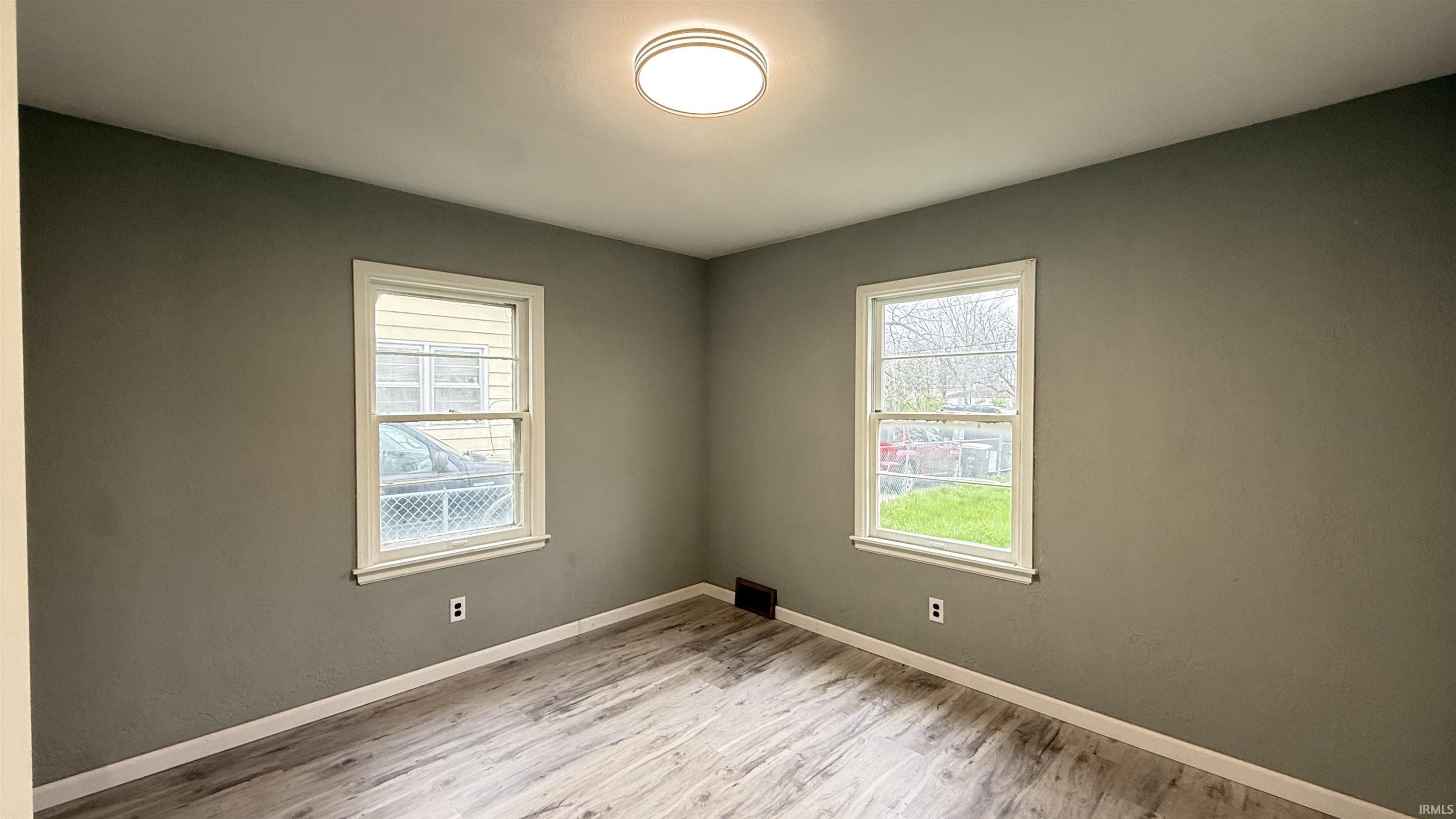 Unfurnished room featuring light wood-style floors and healthy amount of natural light