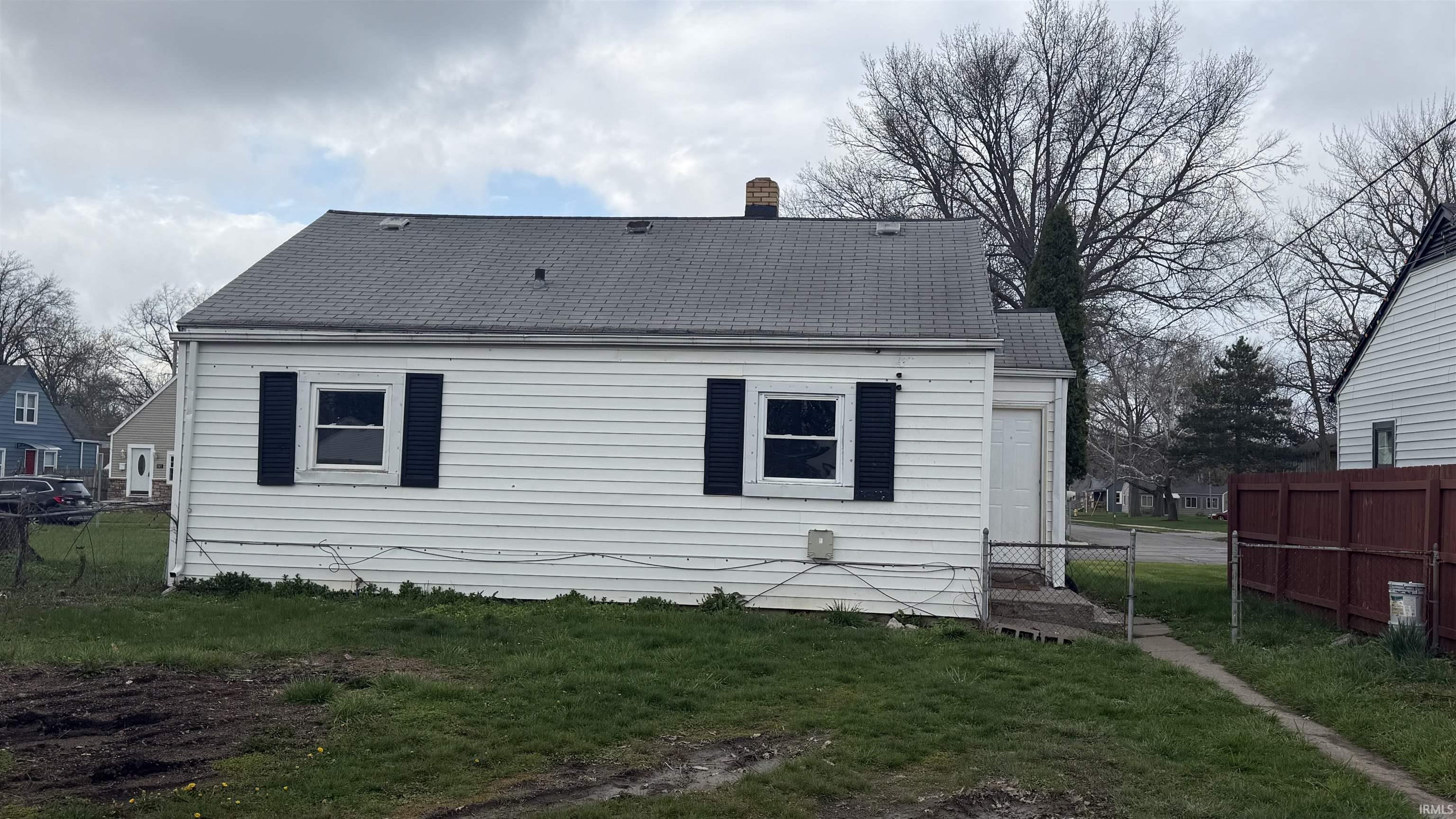Rear view of house with a shingled roof and a chimney
