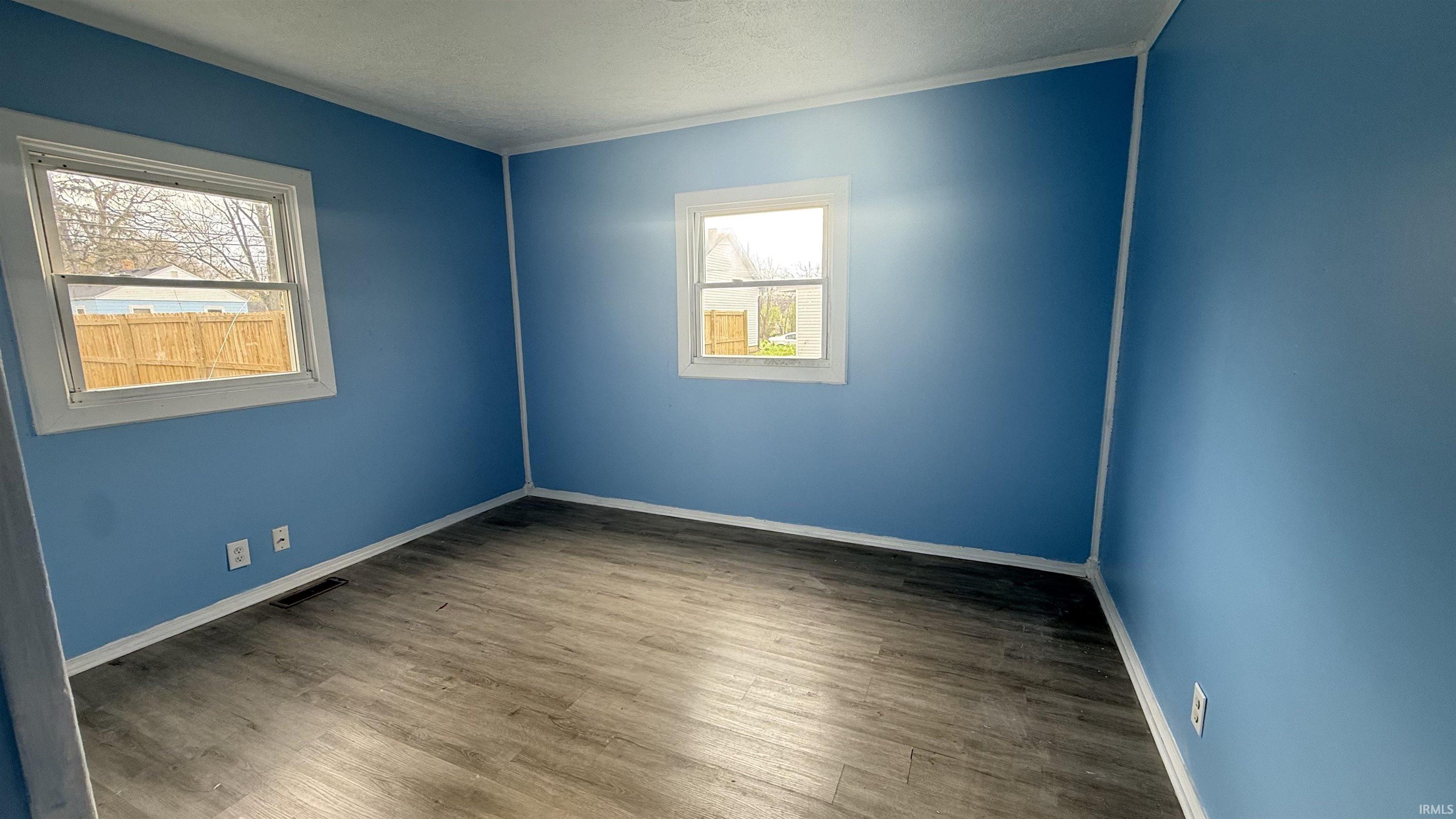 Empty room featuring wood finished floors and a textured ceiling