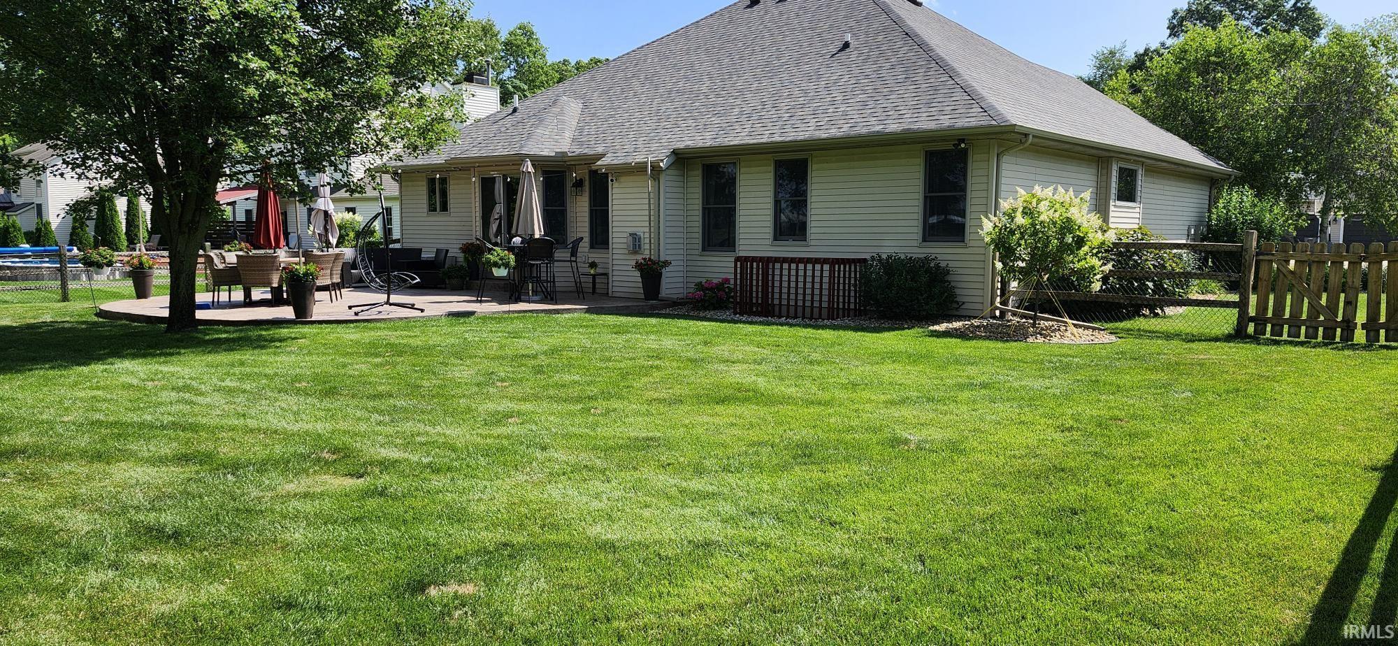 Rear view of property with a patio, a shingled roof, and a chimney