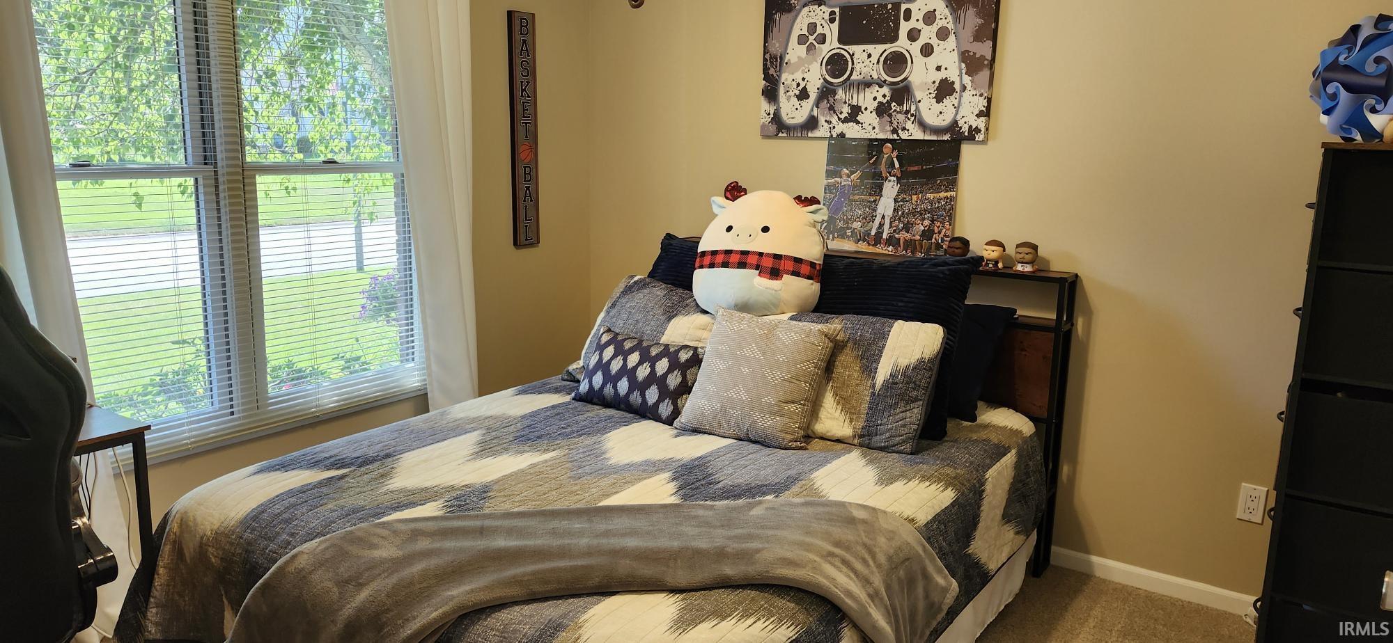 Bedroom featuring carpet and baseboards