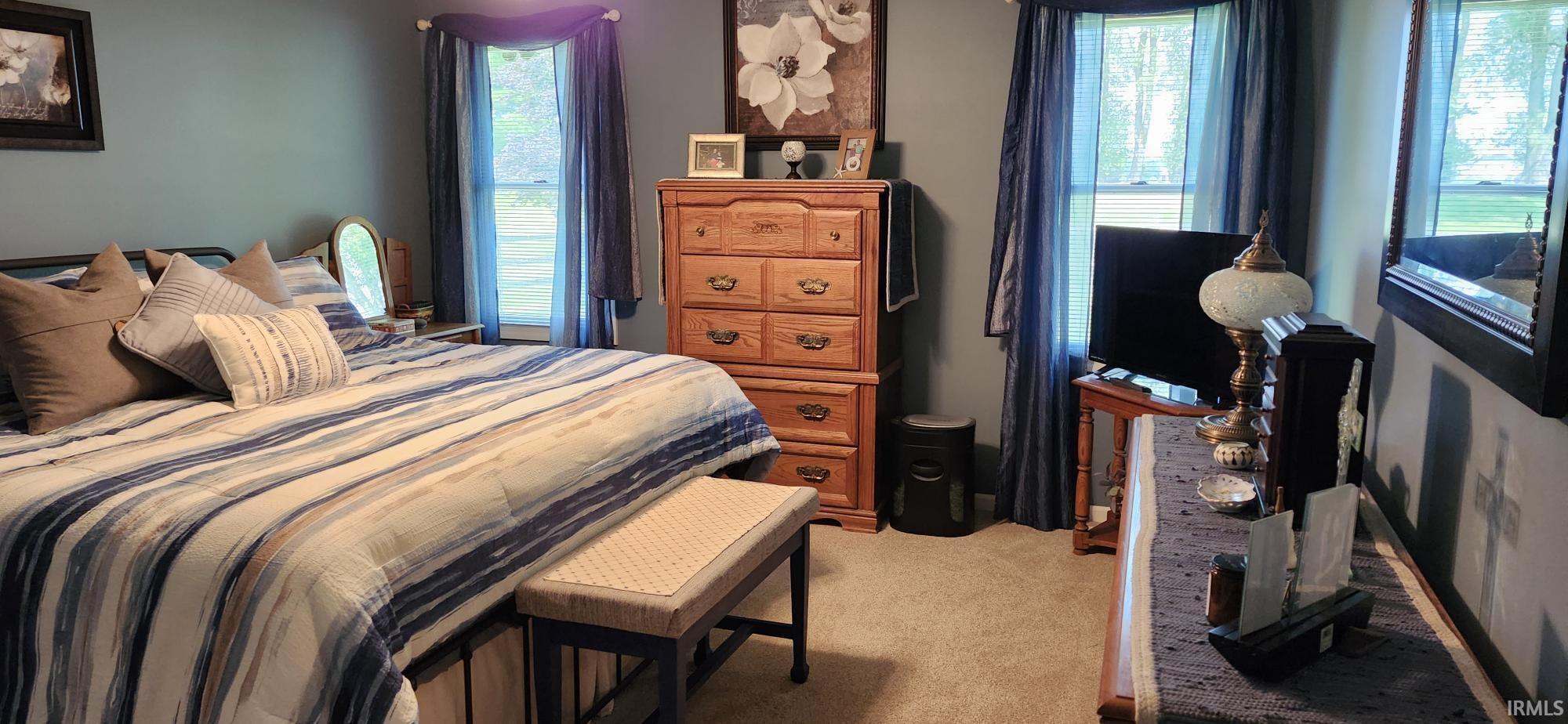 Bedroom featuring light carpet and baseboards