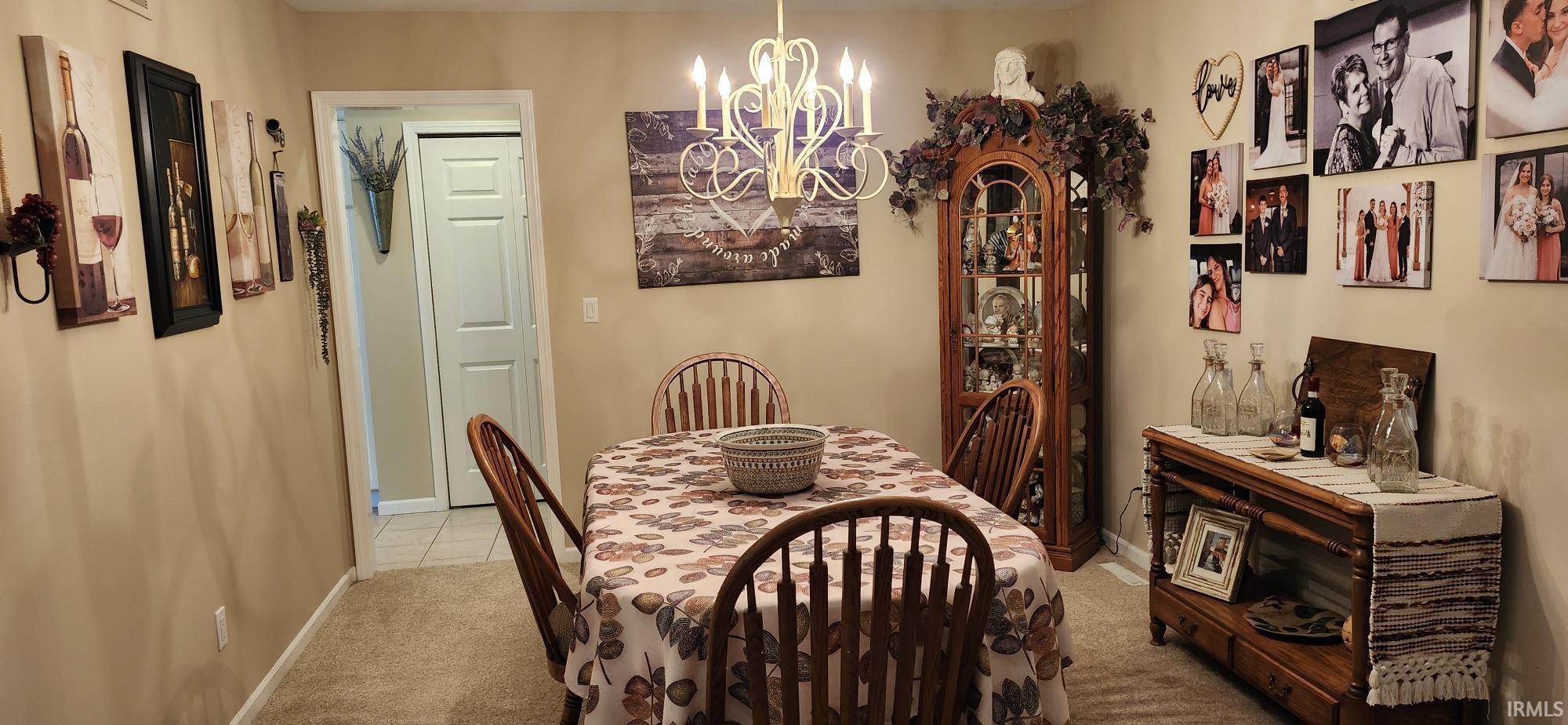 Dining room featuring light carpet and hanging lights