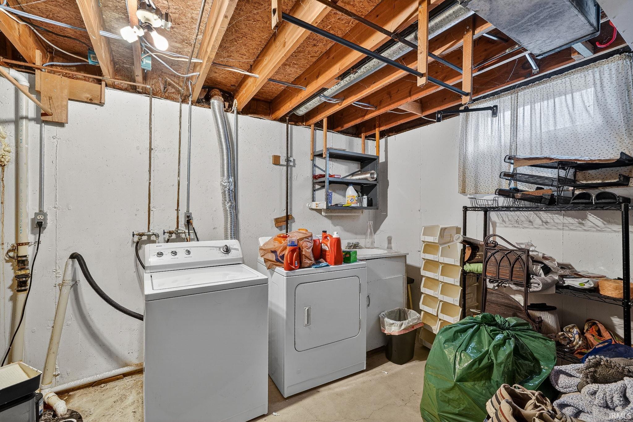 Laundry area featuring washer and clothes dryer and unfinished concrete floors