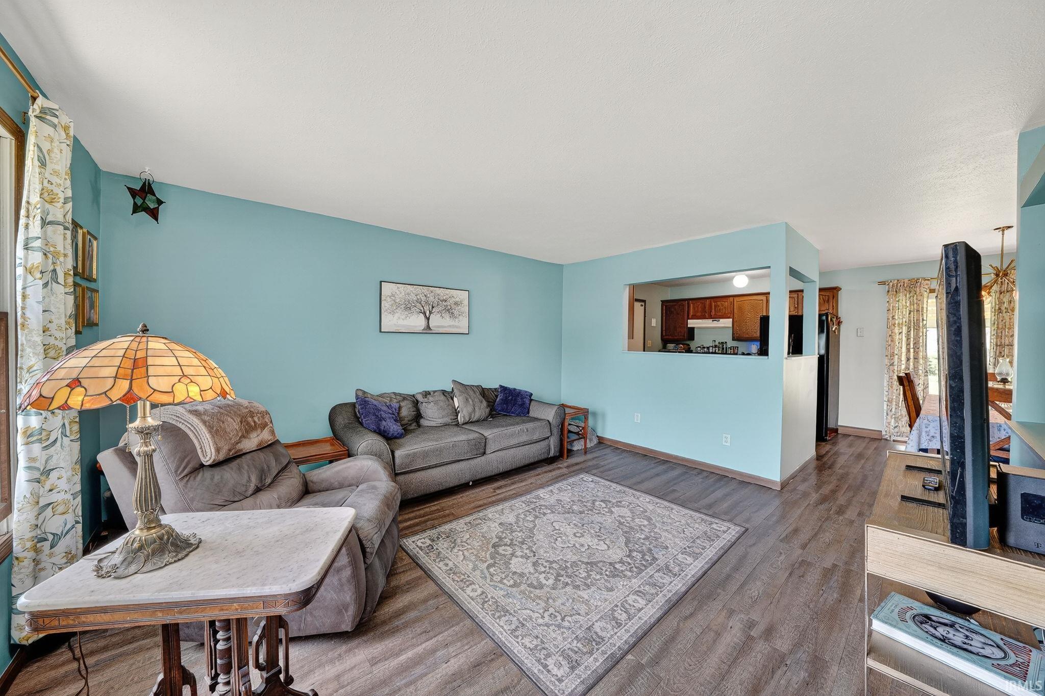 Living room with dark wood-style floors and baseboards